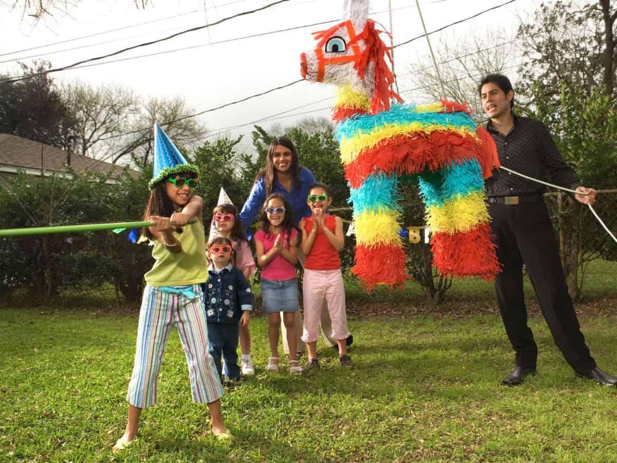 Kids hitting a pinata at Mexican themed party.