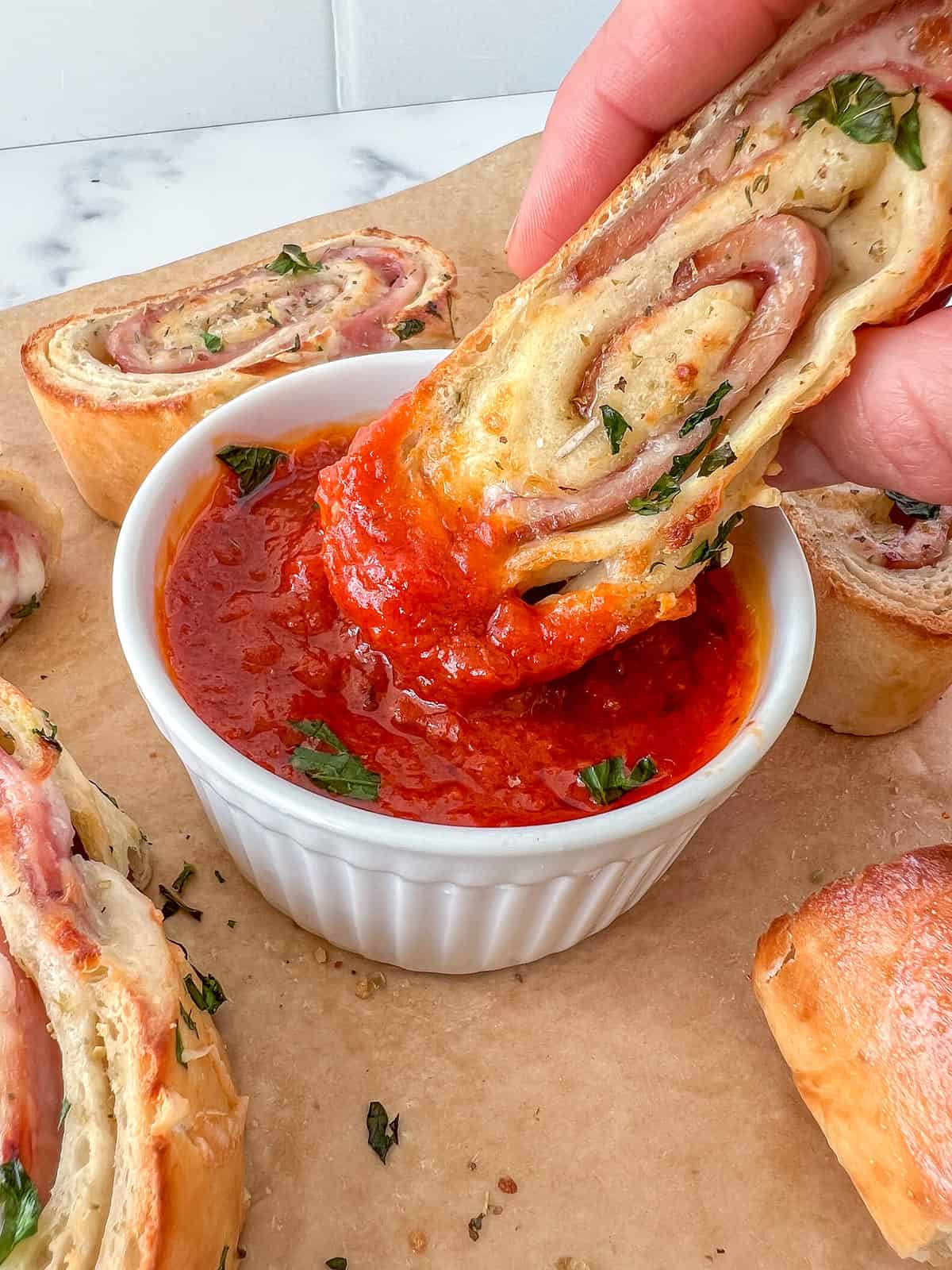 Stromboli stuffed with cheese and meats dipped into tomato sauce.