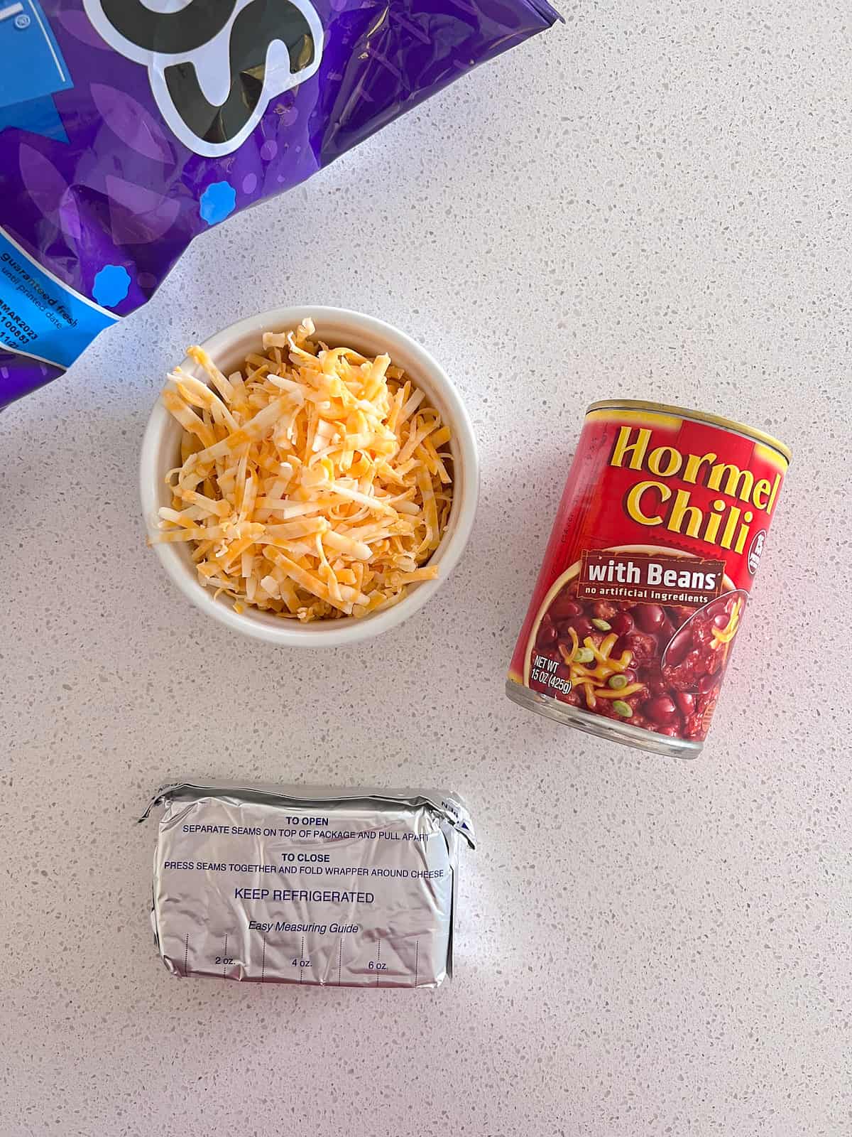 Can of Hormel chili dip with beans, cream cheese, and cheddar cheese omn table.