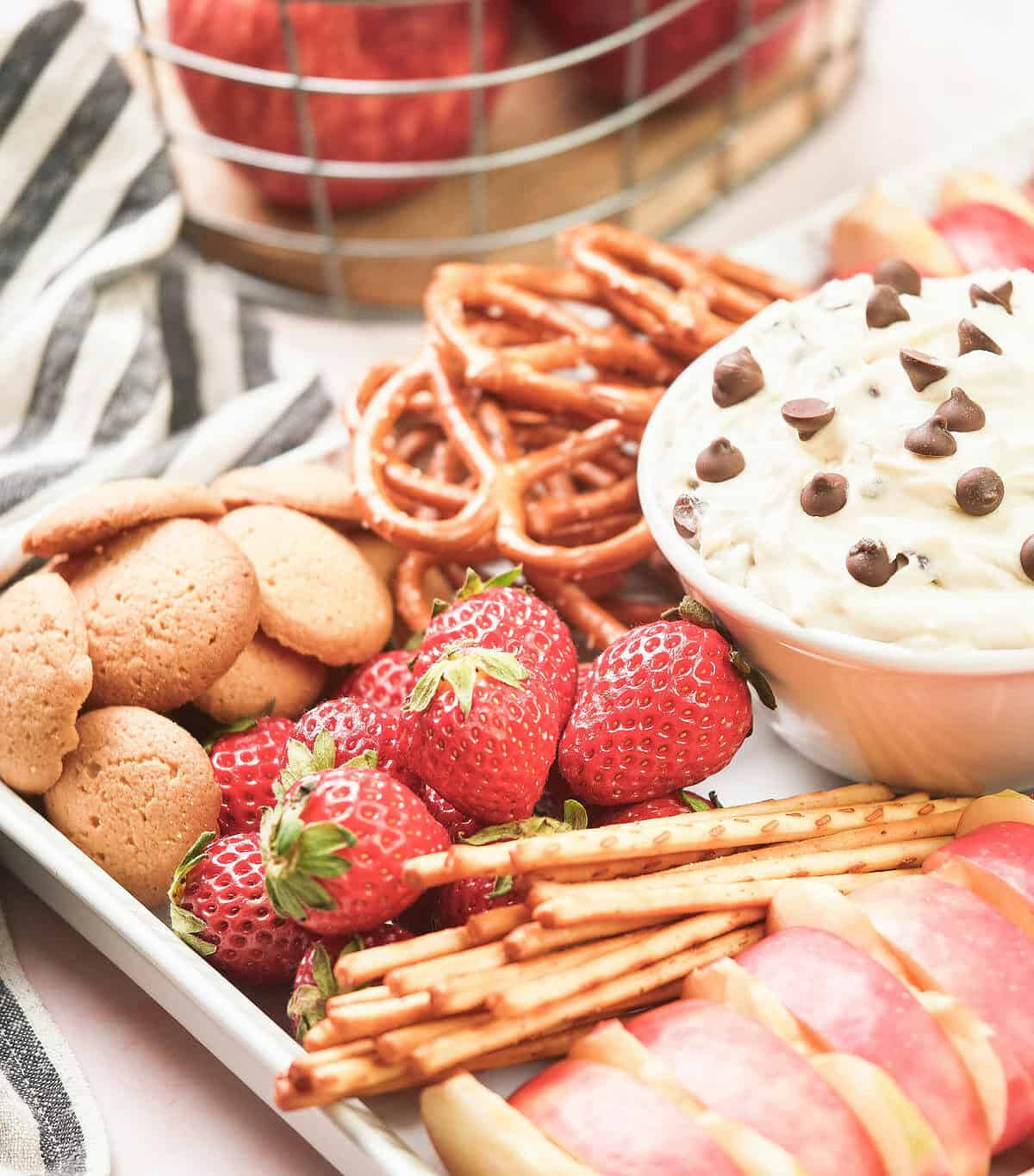 Sweet chocolate chip cookie dip with dippers on platter.