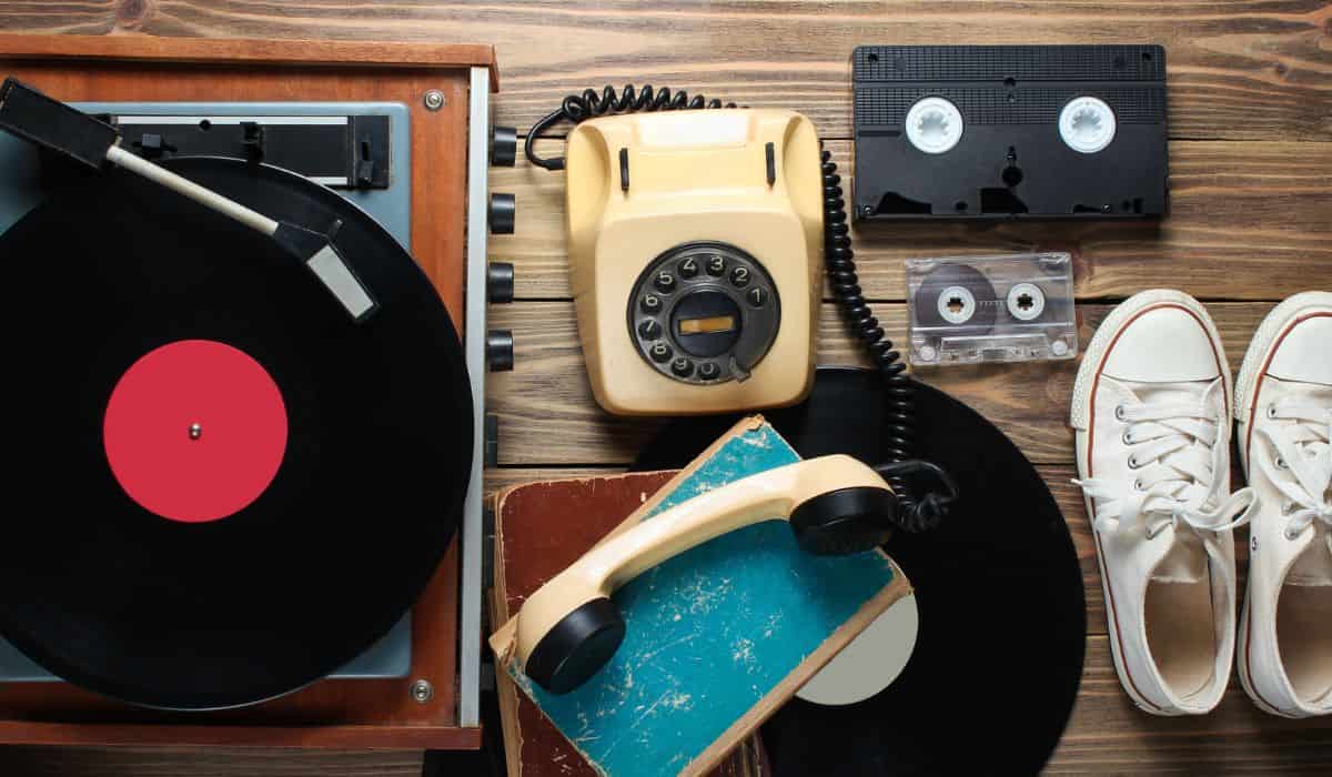 19080s things like a phone, shoes, cassette taoe and record on table.