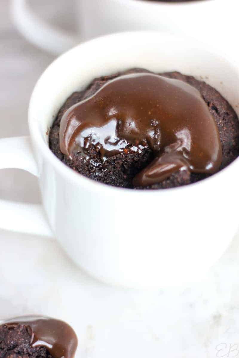 chocolate caramel mug cake topped with chocolate sauce.