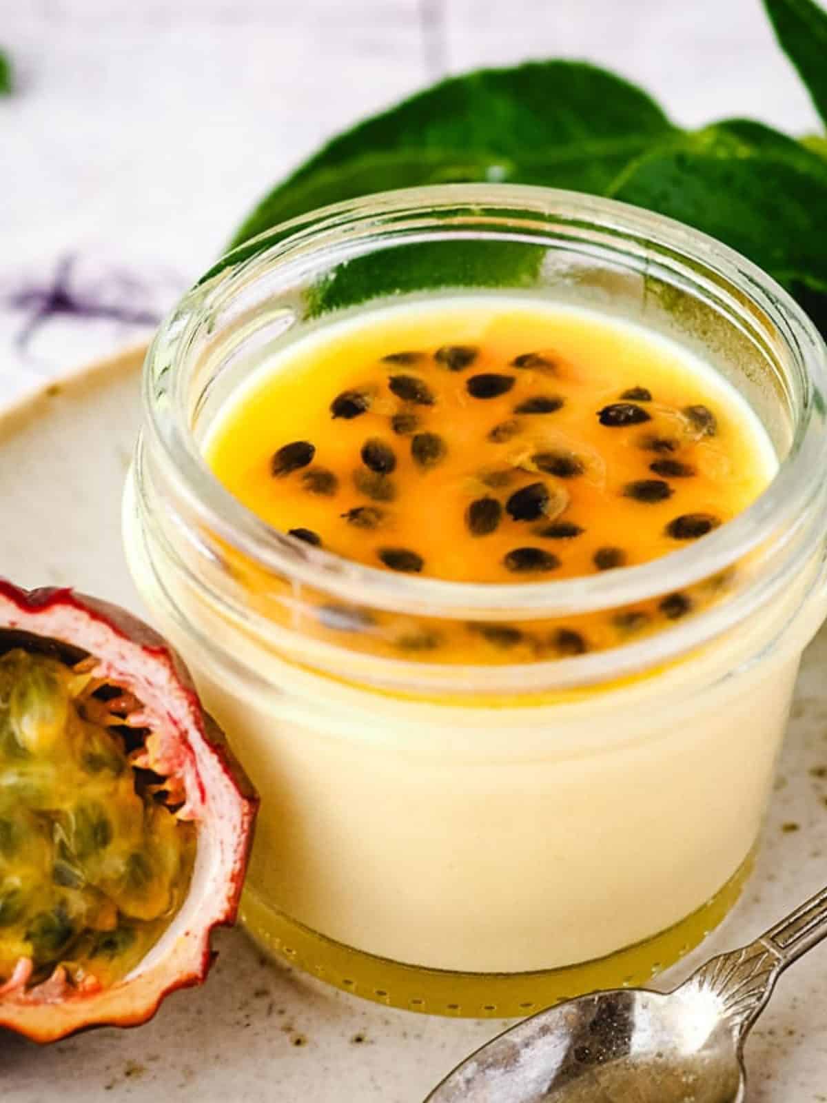 passion fruit panna cotta in a small jar with fresh passion fruit.