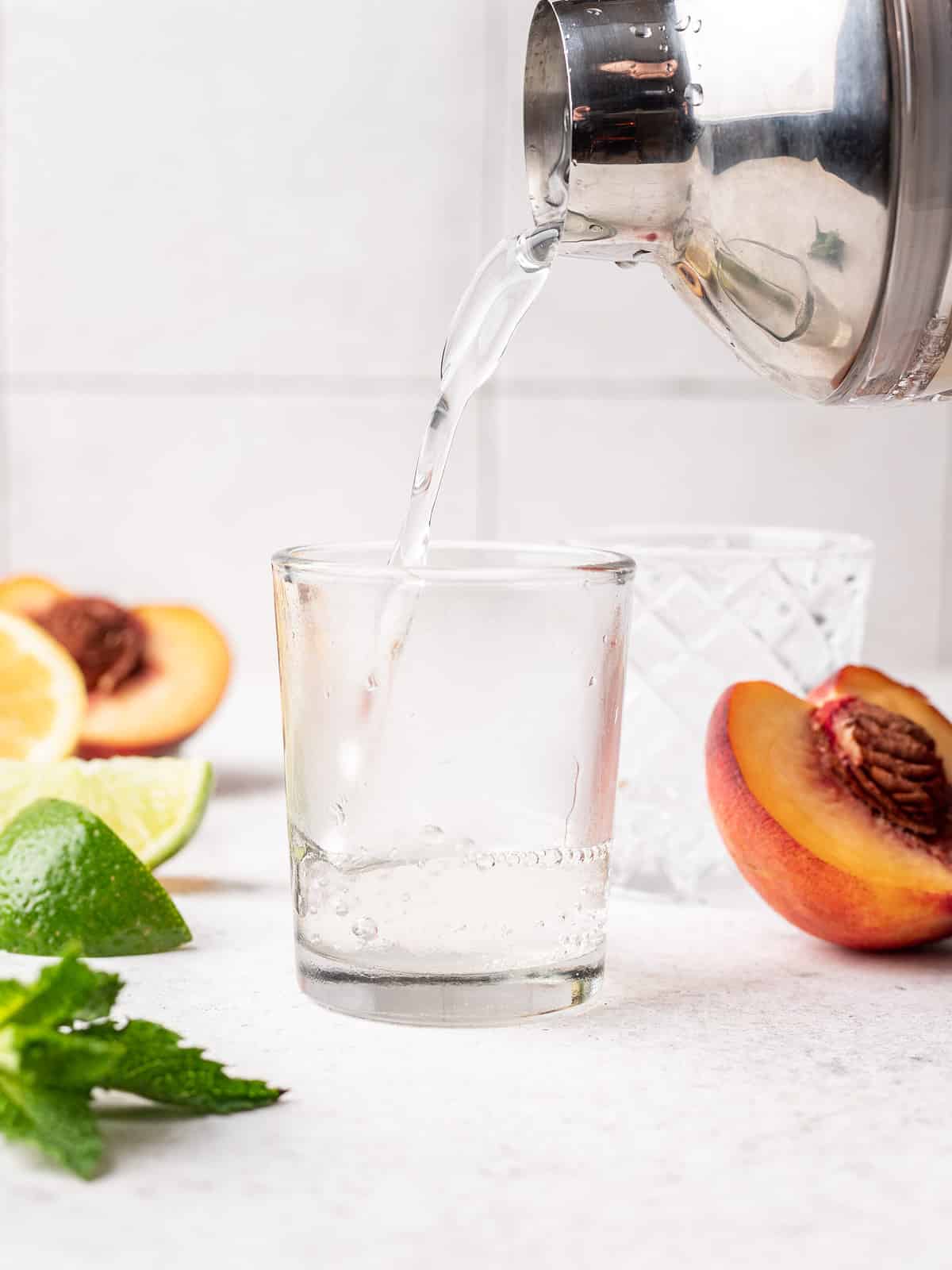 Pouring white tea shot into shot glass.