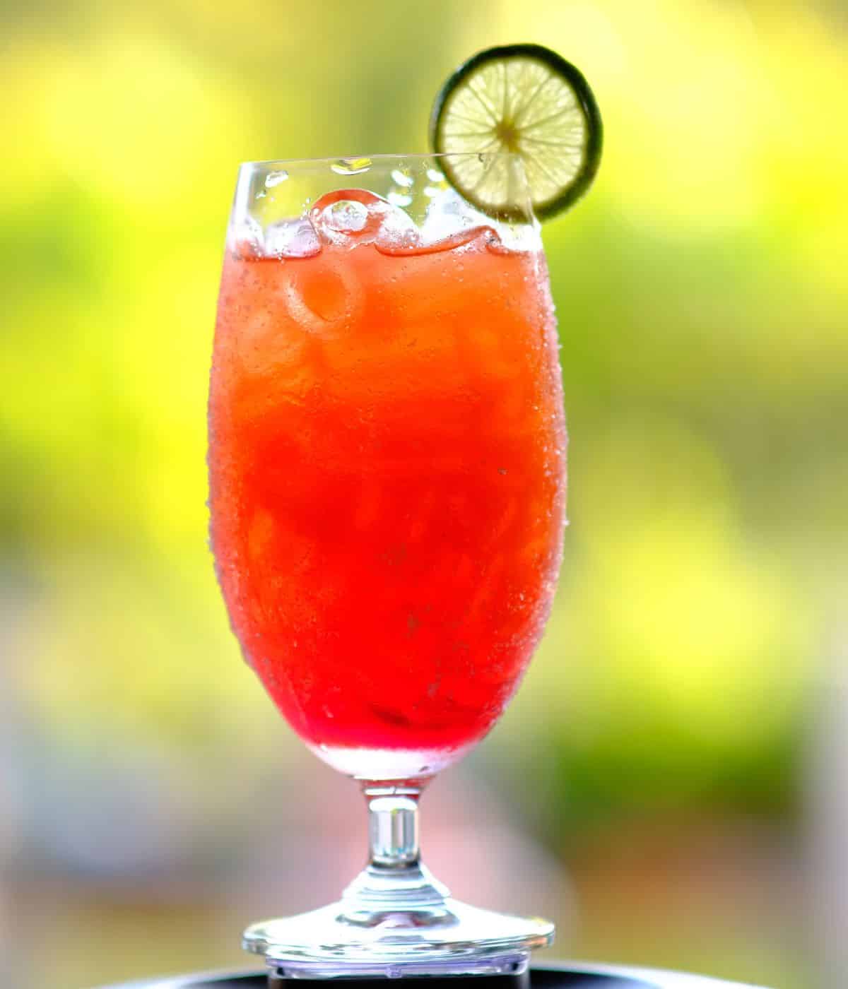 Fruit punch cocktail with lime wheel.
