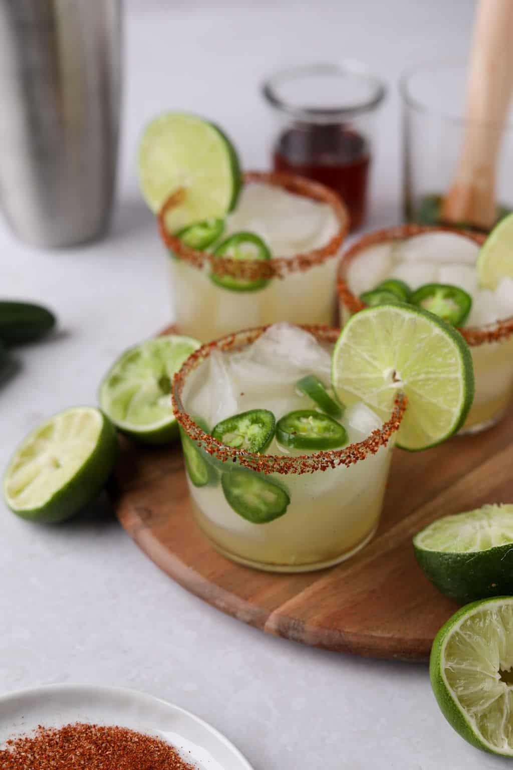 Jalapeno margaritas on board with jalapeno slices.