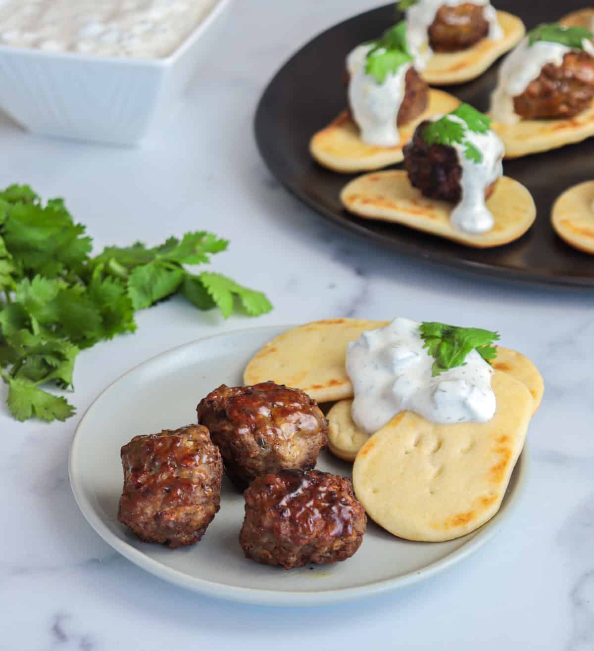 Lamb meatballs with bread and sauce on the side.