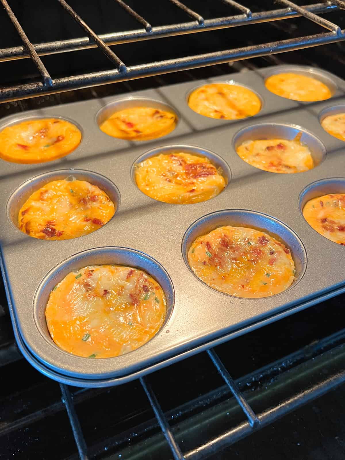 Egg bites in muffin tin in oven.