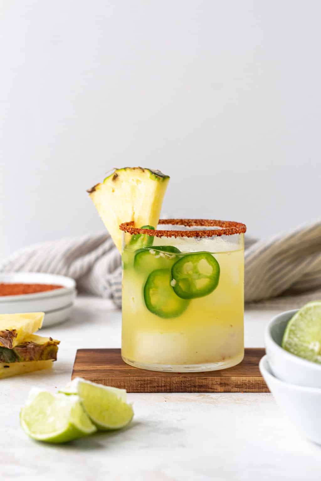 Spicy pineapple margarita with jalapeno slices and pineapple wedge.