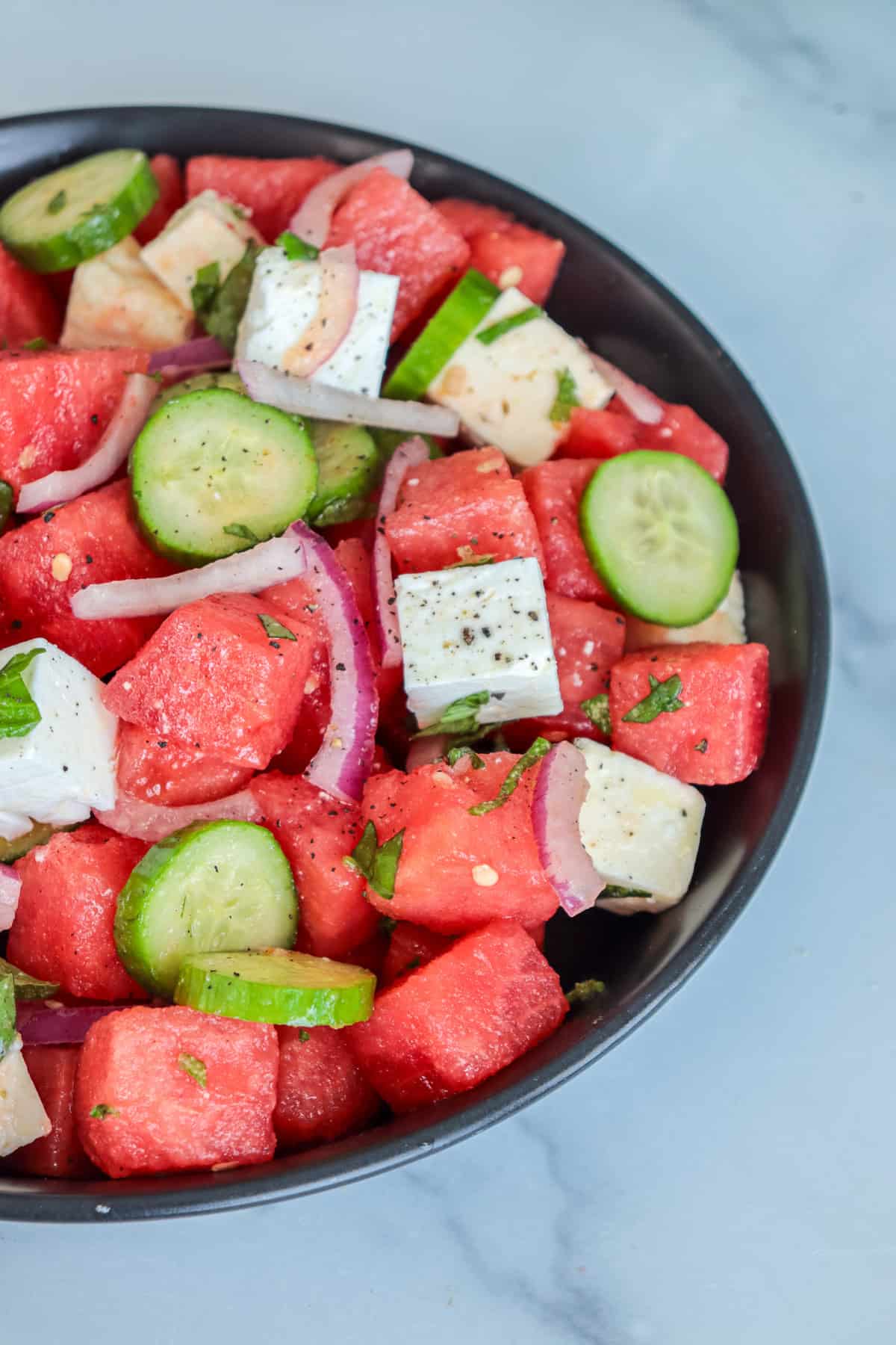 Watermelon feta salad with onions and cucumbers.