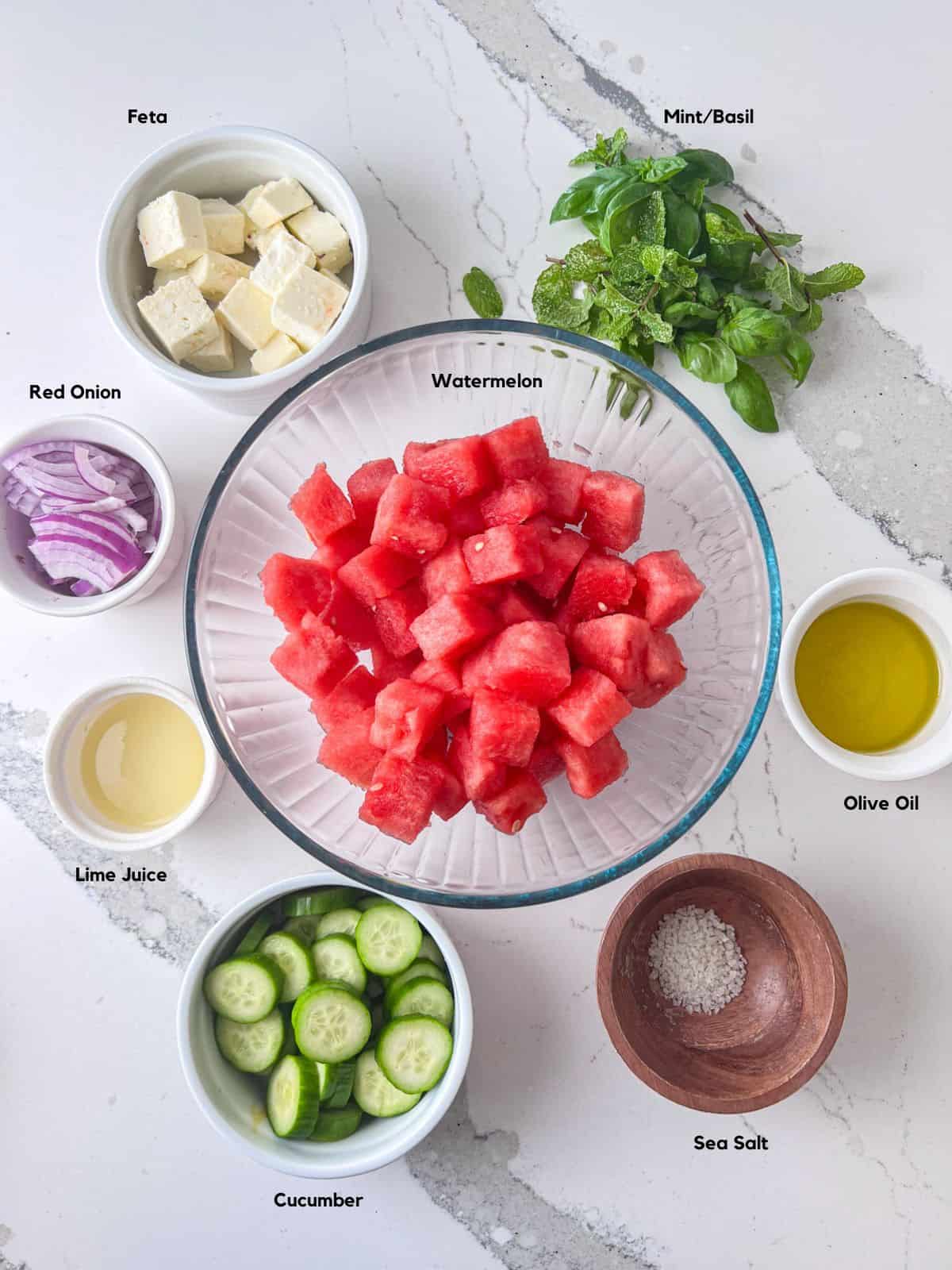 Ingredients to make a watermelon feta salad on table.
