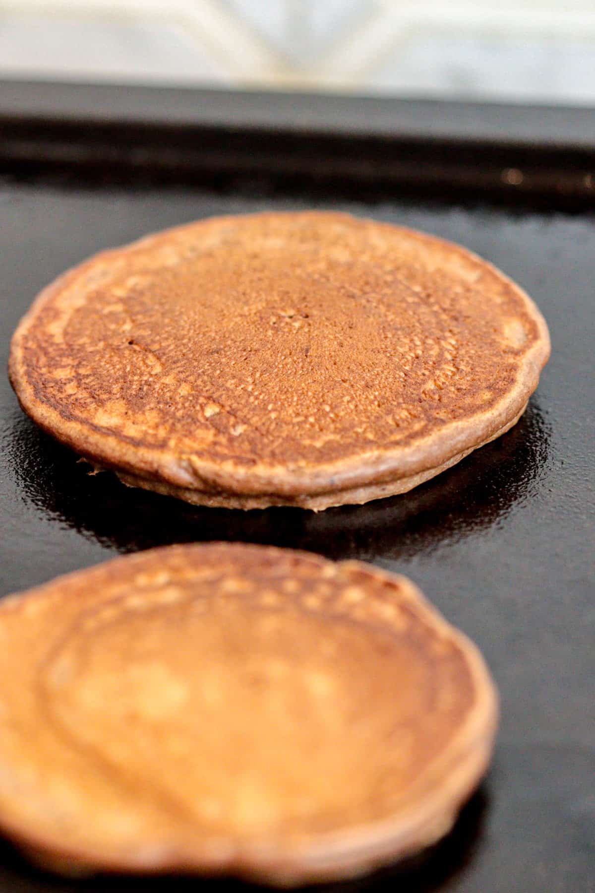 Chocolate pancake being cooked on a griddle.