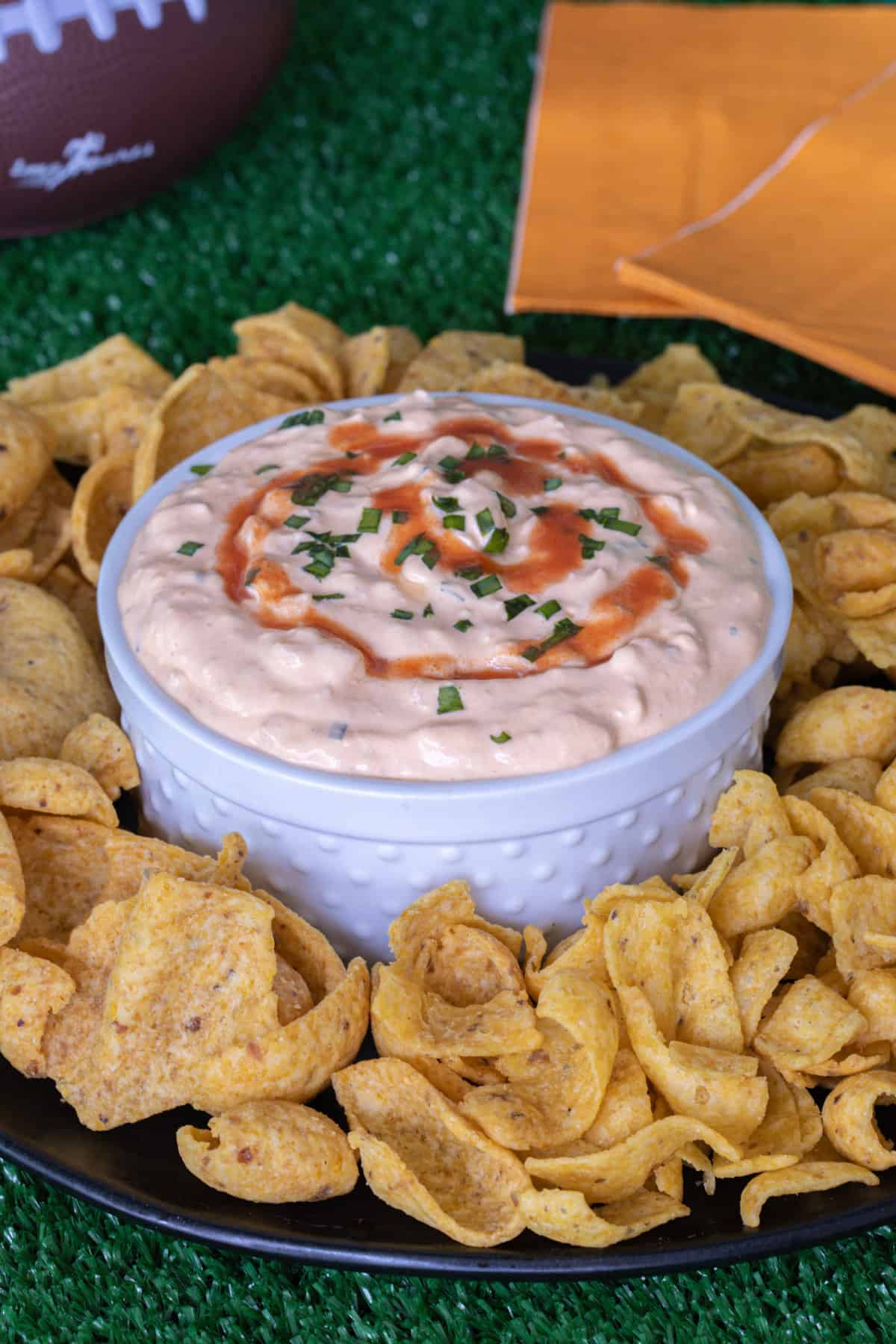 Buffalo onion dip with fritos on a plate.