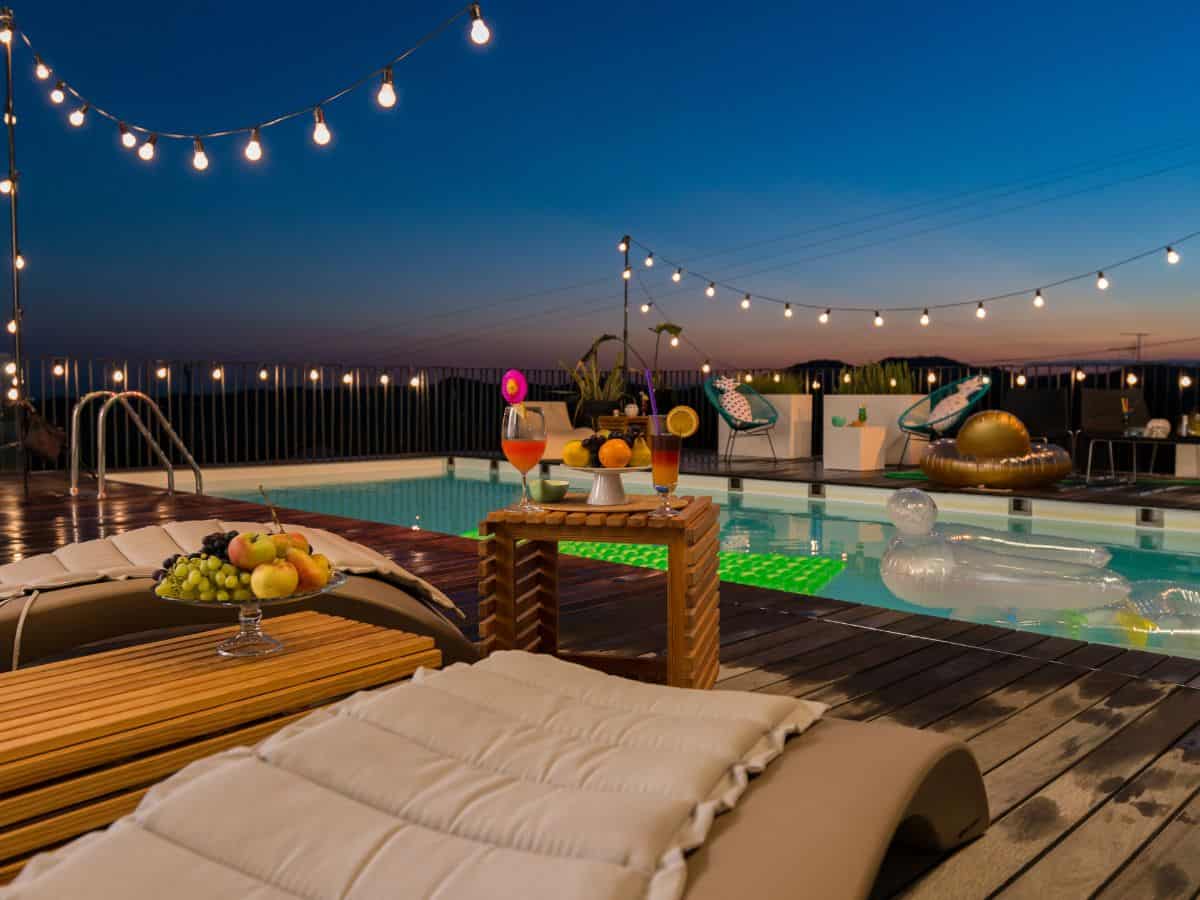 Pool with floaties, lights and food for party.