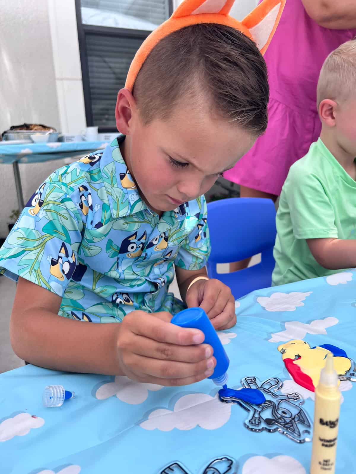 Lucas painting Bluey figurines.