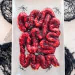 Spooky gruesome intestines appetizer on plate with fake spiders.