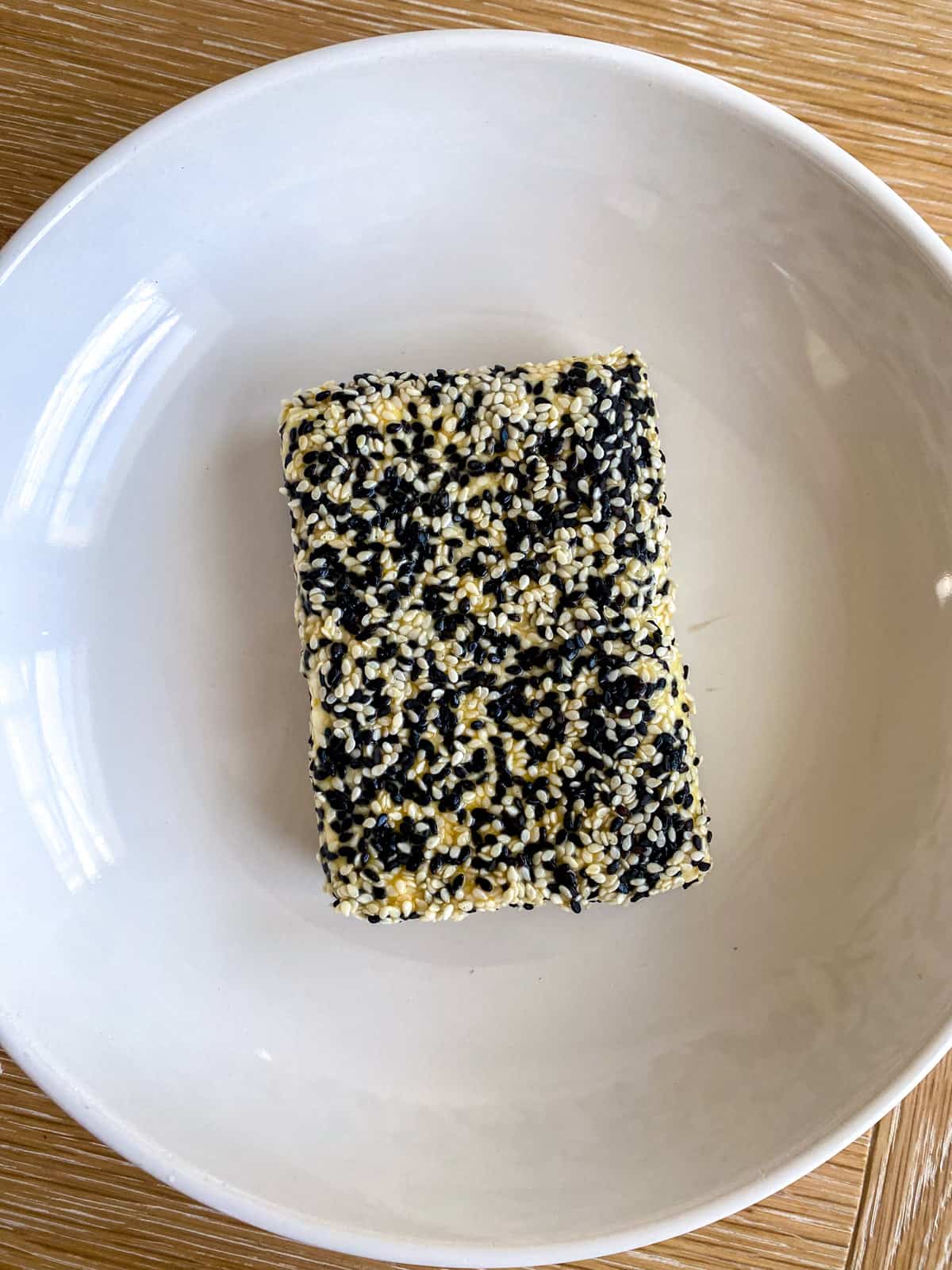 Feta cheese coated in sesame seed crust before frying.