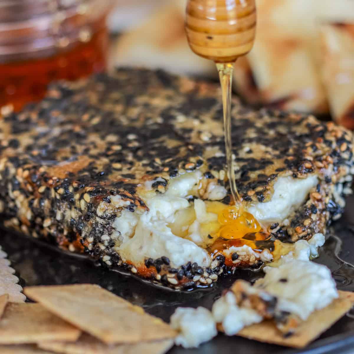 Fried feta cheese with honey being drizzled over top.