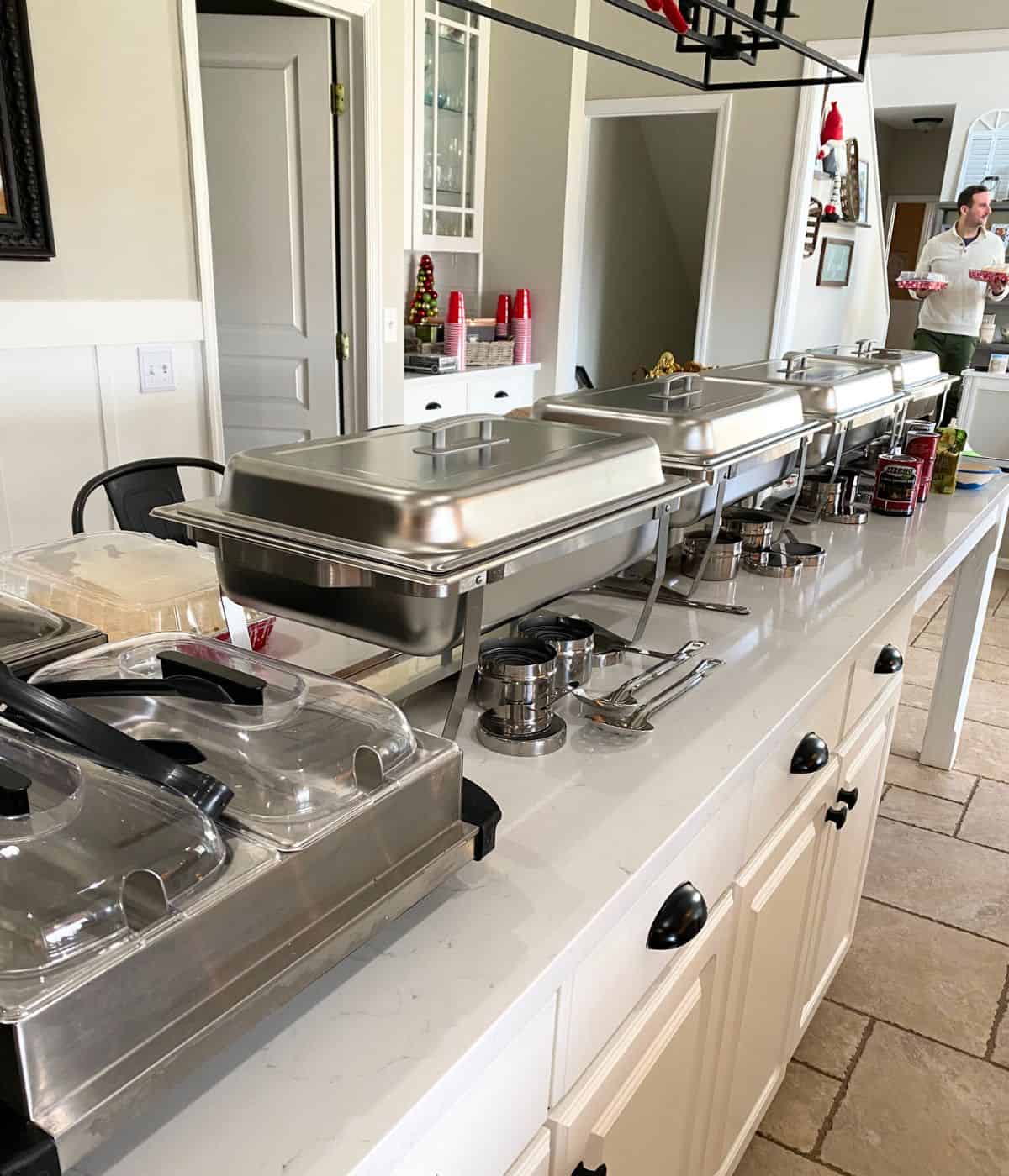 Chafing dishes set up on island in kitchen.