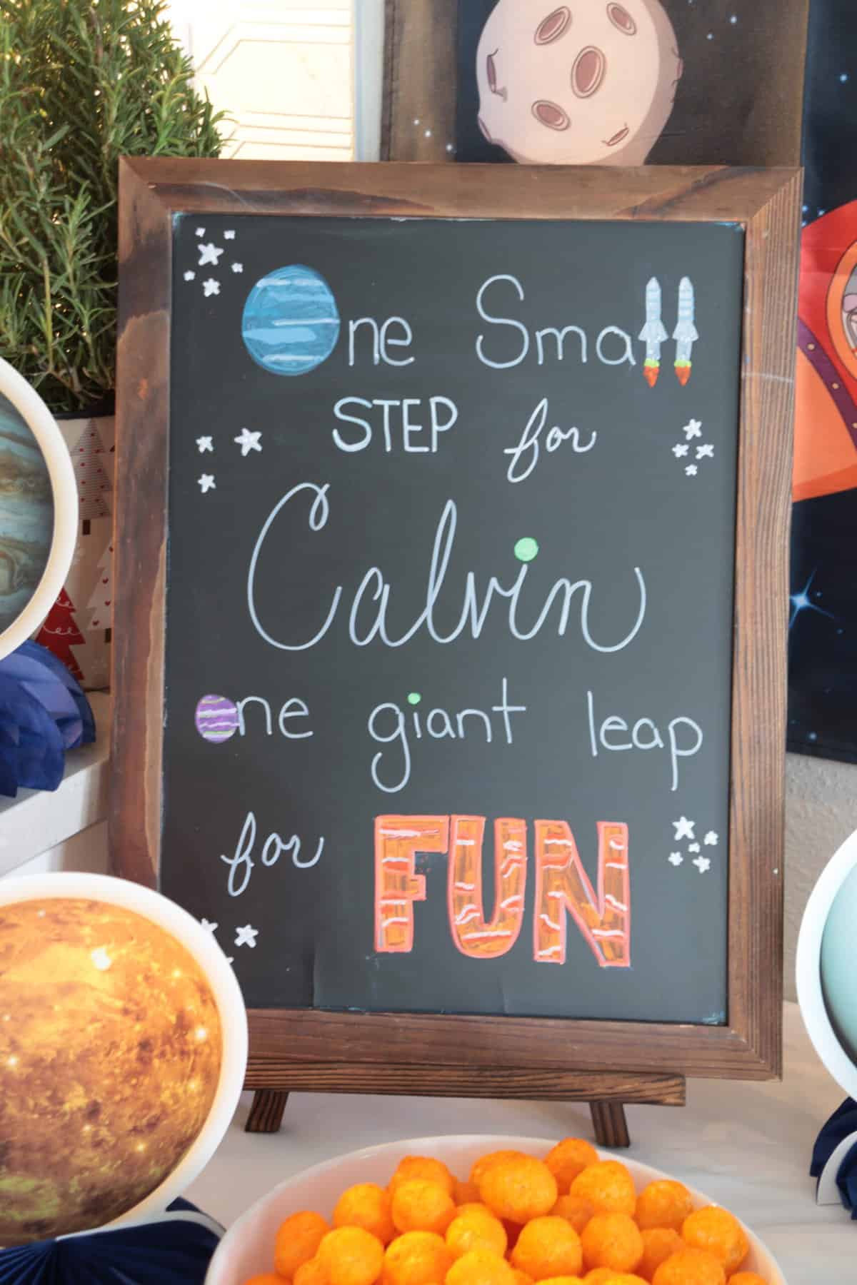 Chalkboard sign with a space themed message.