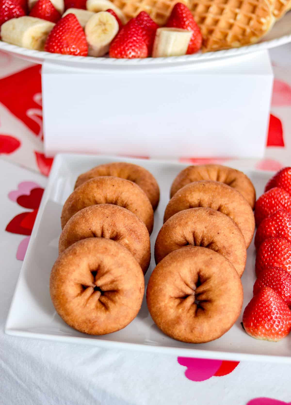 Donuts and strawberries on plate.