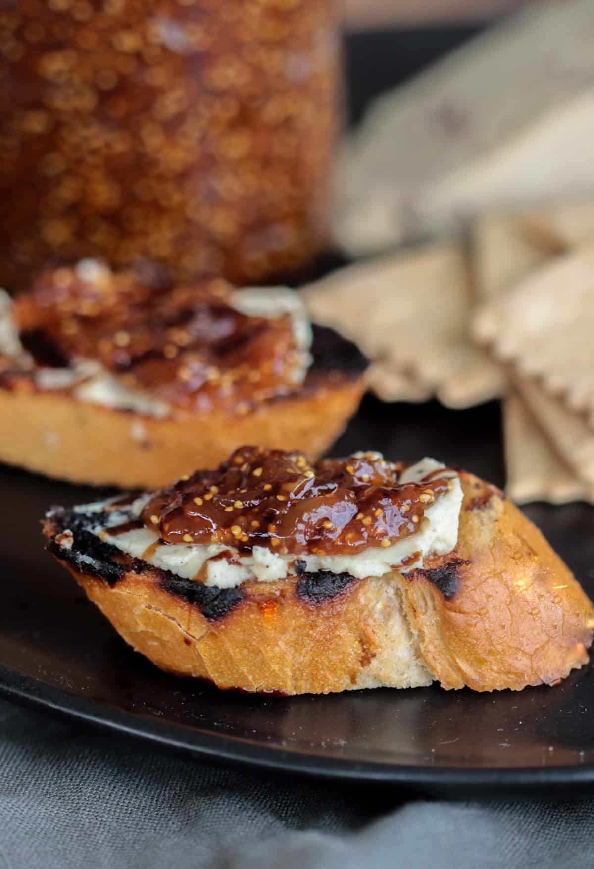 Dried fig jam spread on crostini with cheese and a balamic glaze.