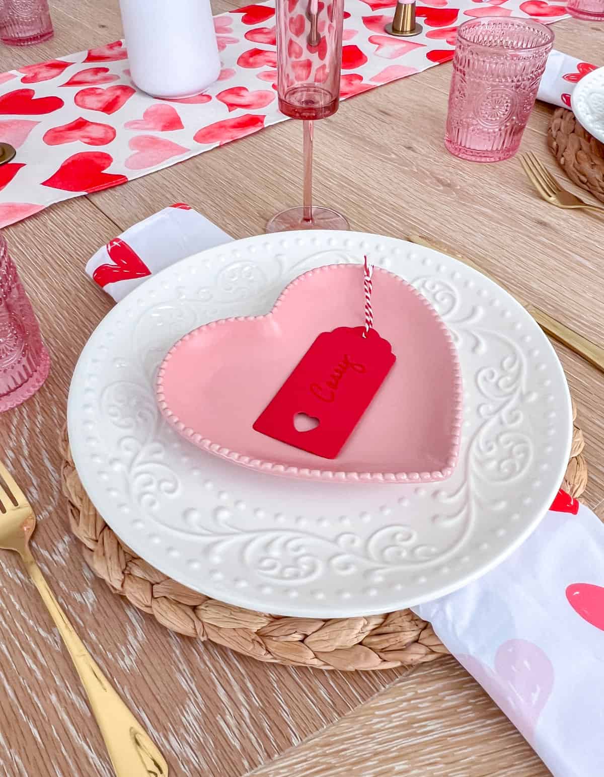 Place setting with pink heart plate and red name tag.