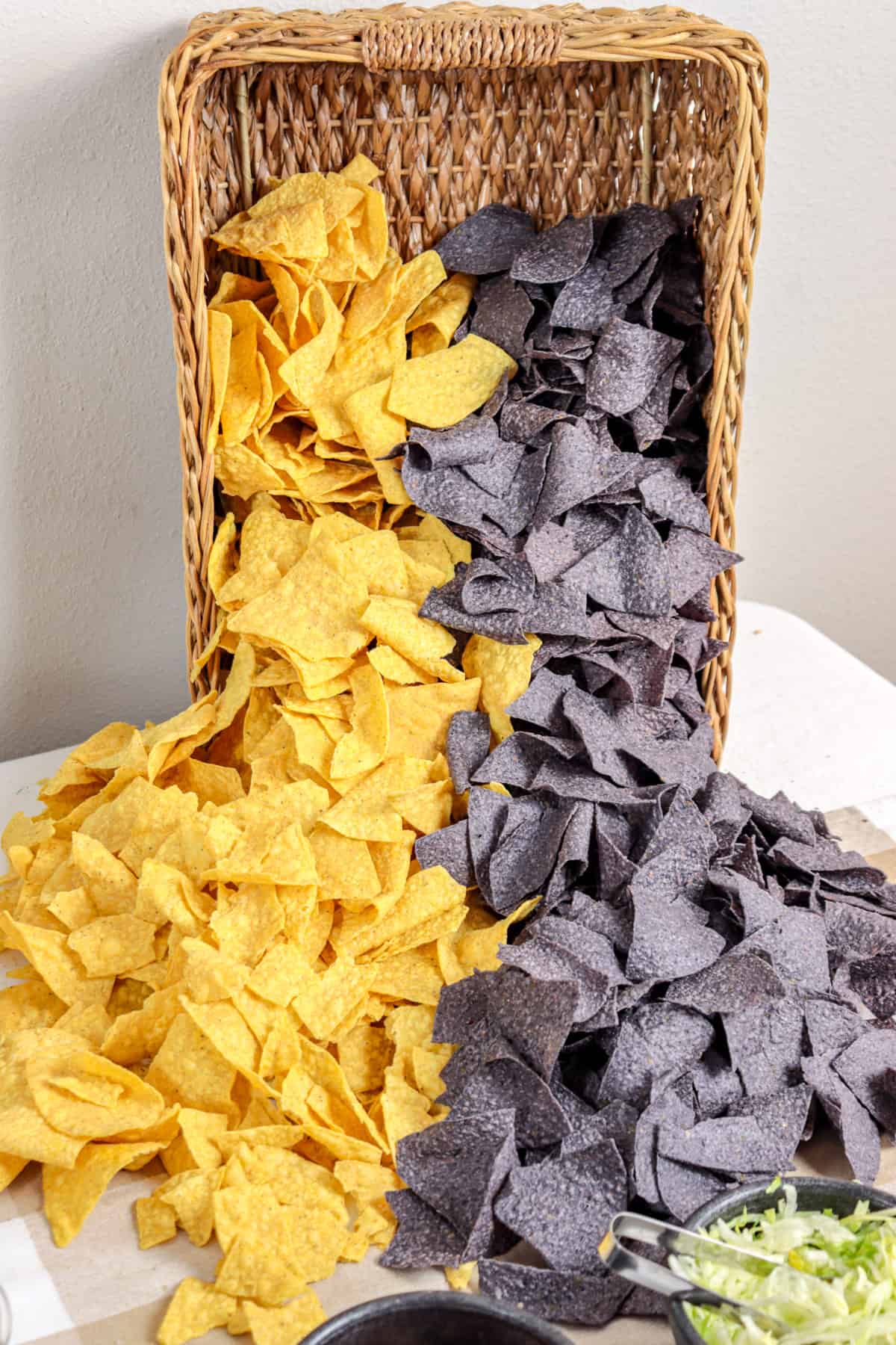 Yellow and blue tortilla chips cascading out of a basket.