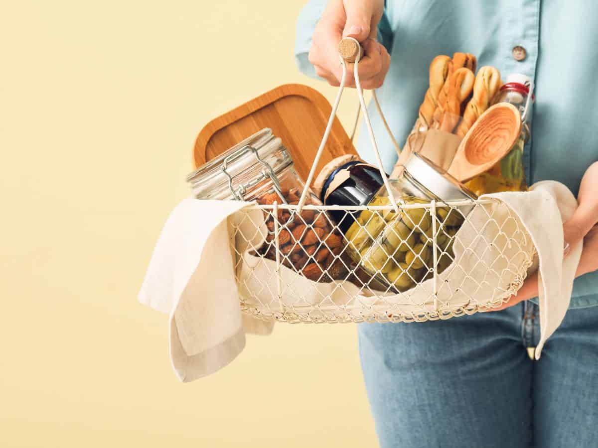 Host gift basket with olives, nuts and cutting board.