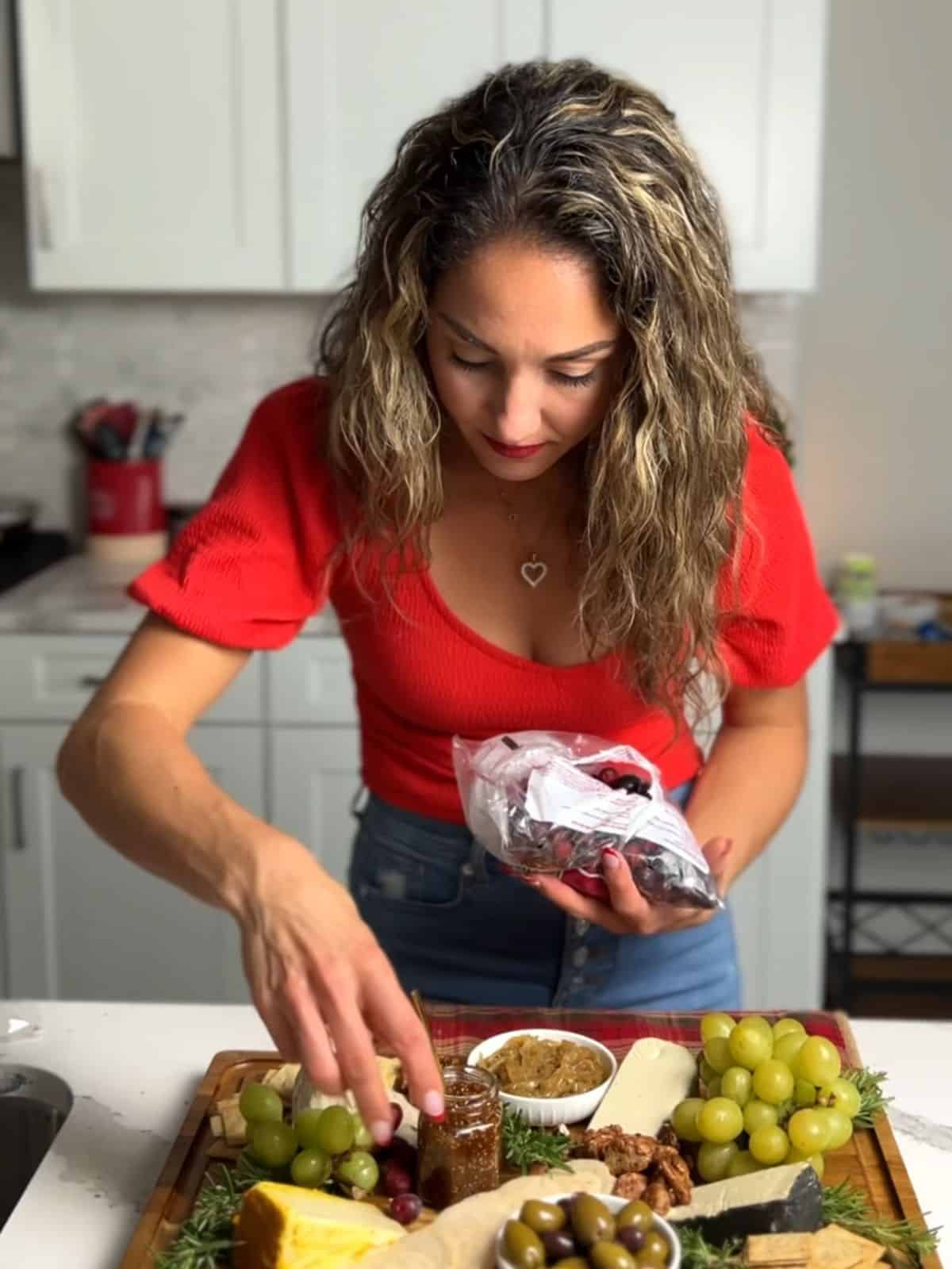 Aleka setting up a charcuterie board for a party.