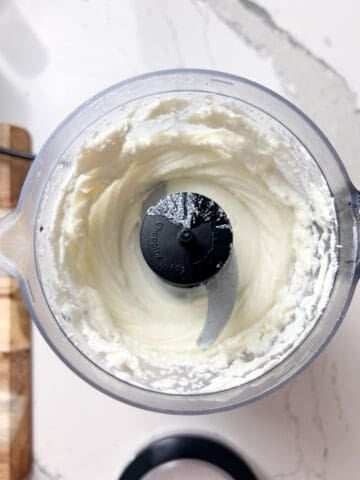 Goat cheese and cream in a food processor.