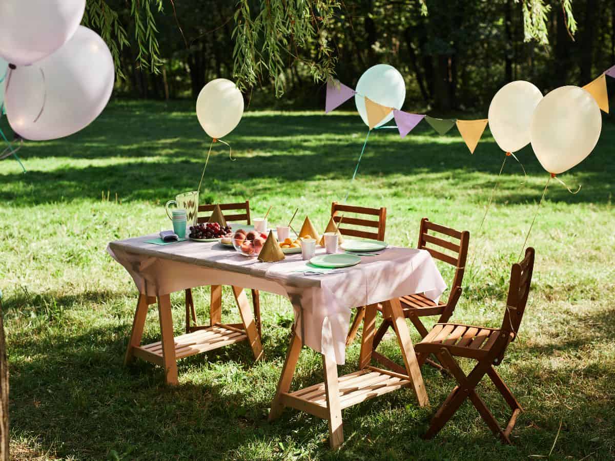Birthday table outside with balloons.