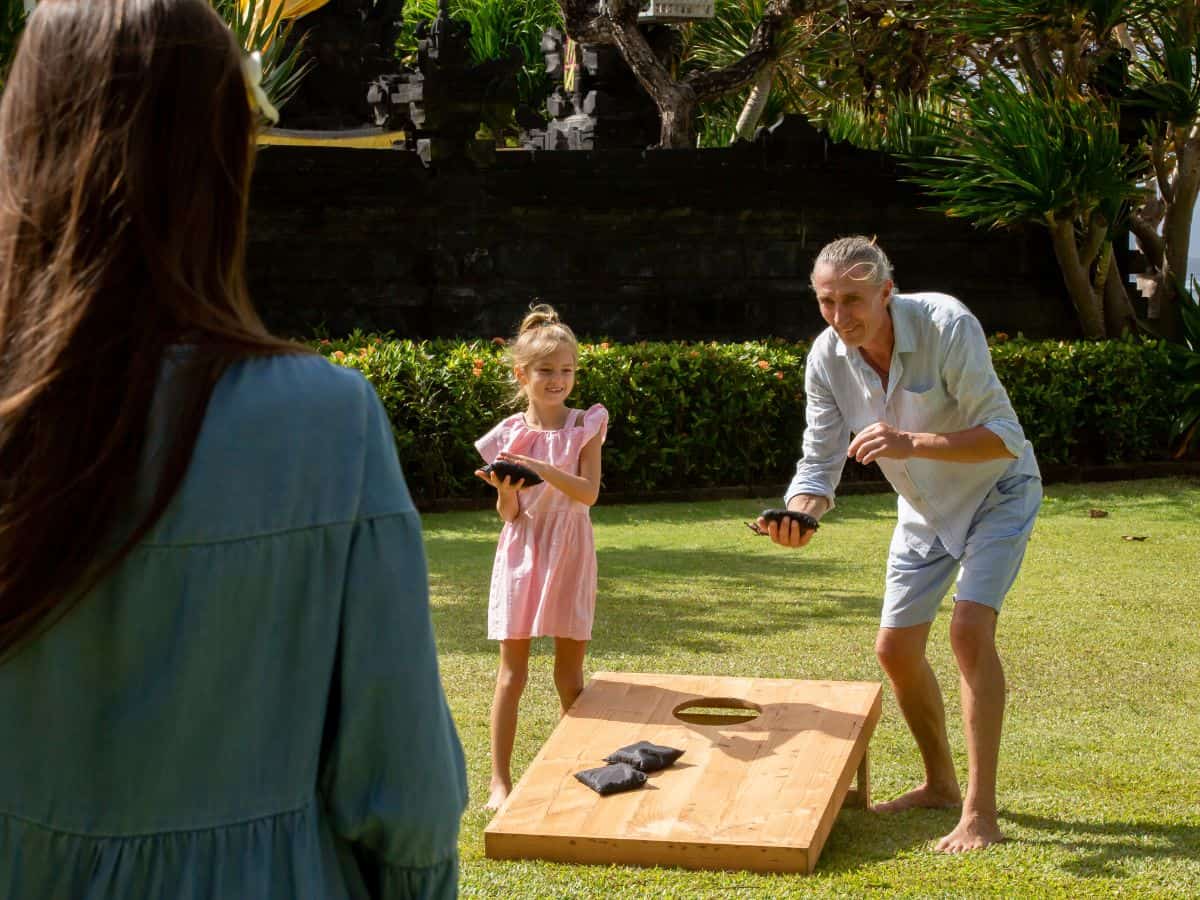 Guests playing cornhole at birthday party.