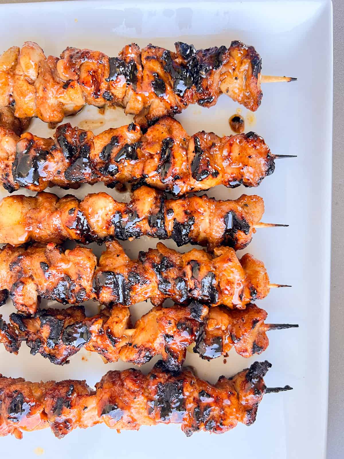 Chicken kabobs on plate with glaze.