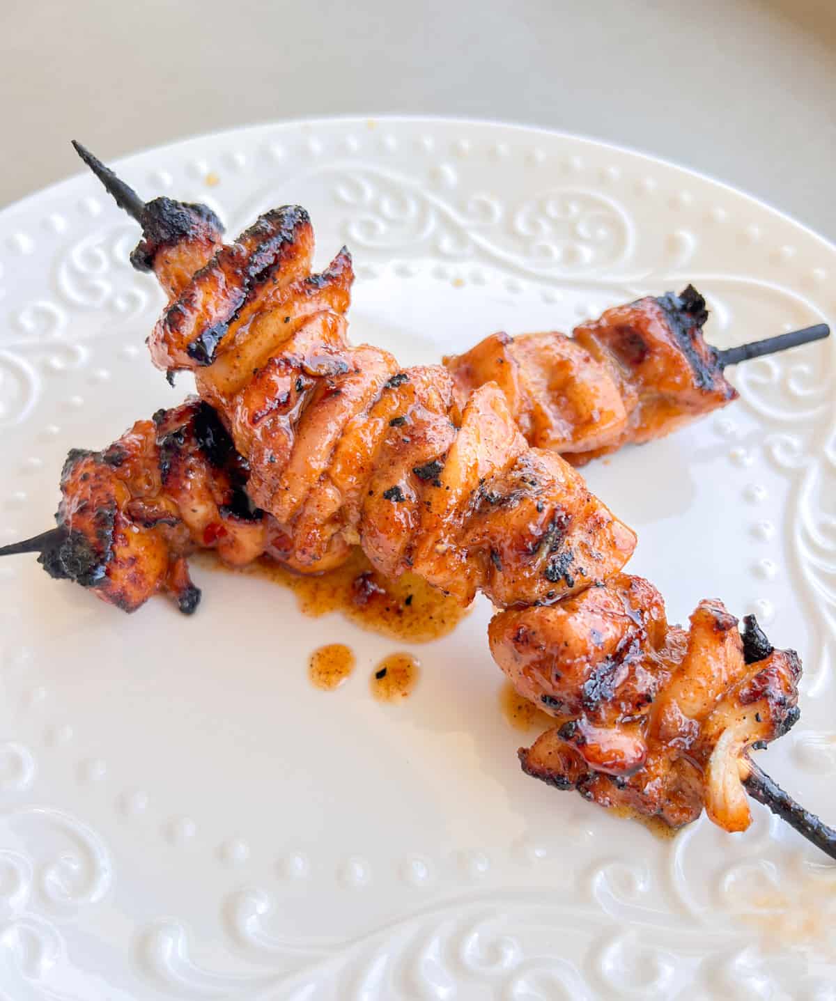 Grilled chicken kabobs on a plate.