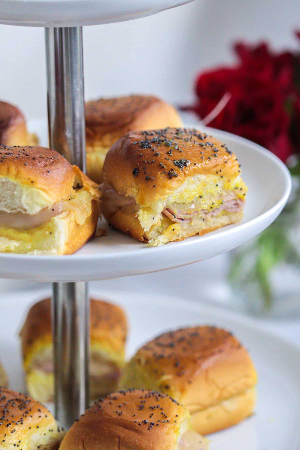 Hom and cheese sliders on a tiered platter.