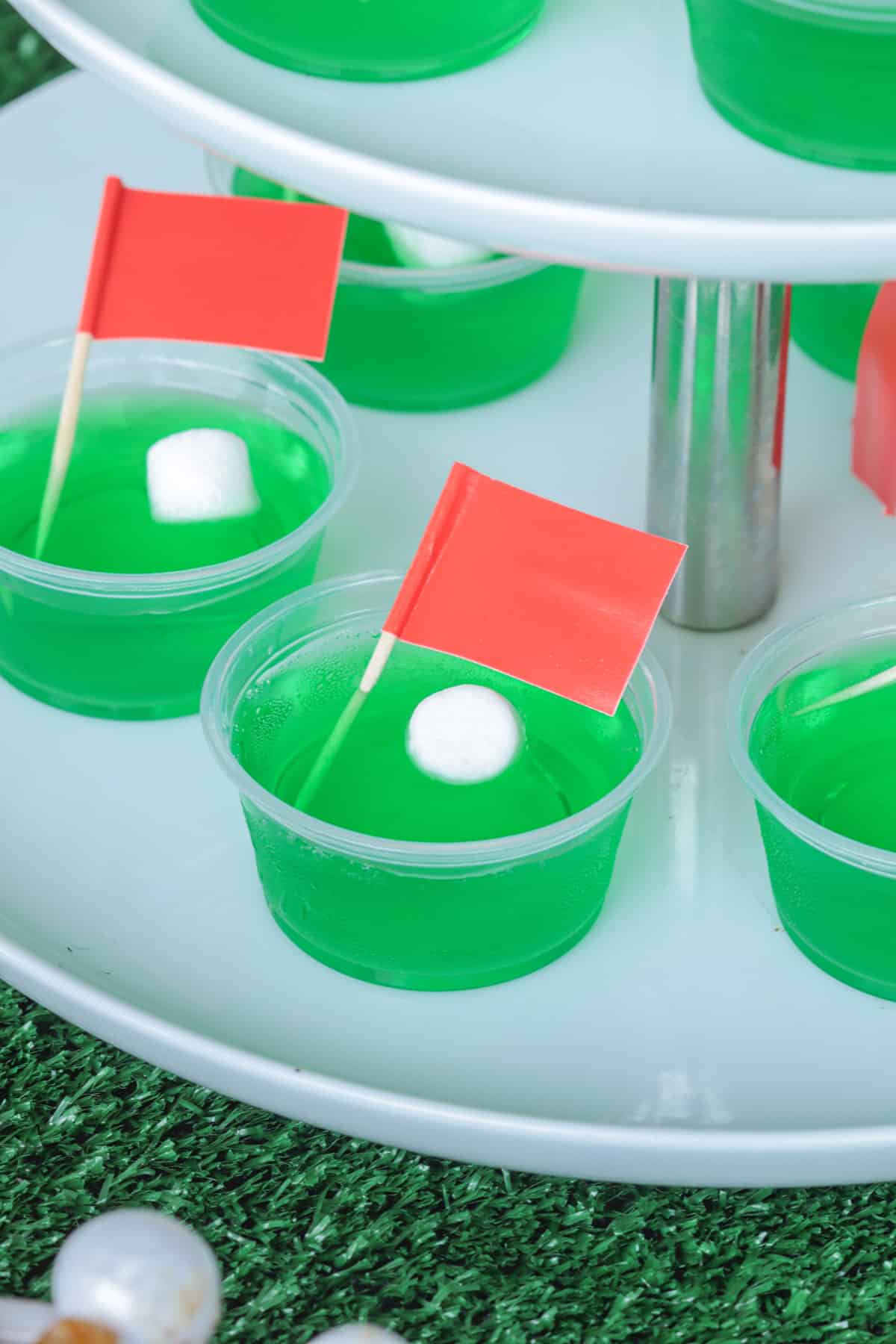 Green Jello shots with red flags and white marshmallow ball.