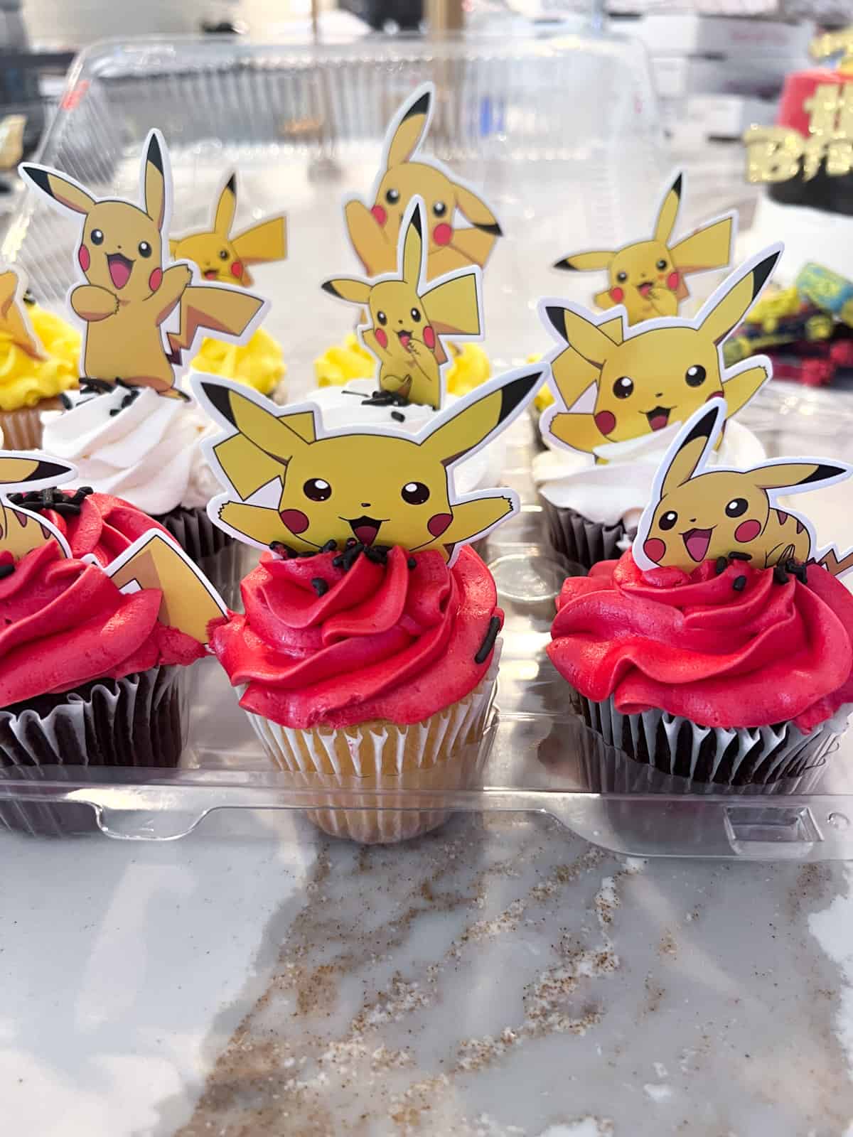 Pokemon cupcakes with pikachu on top.