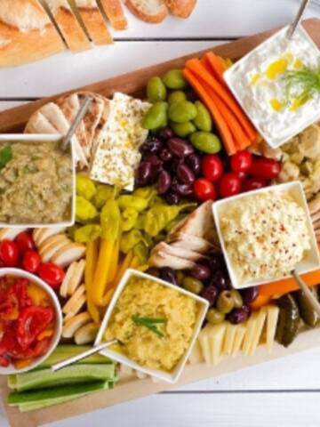 Greek appetizer spread on a cutting board.