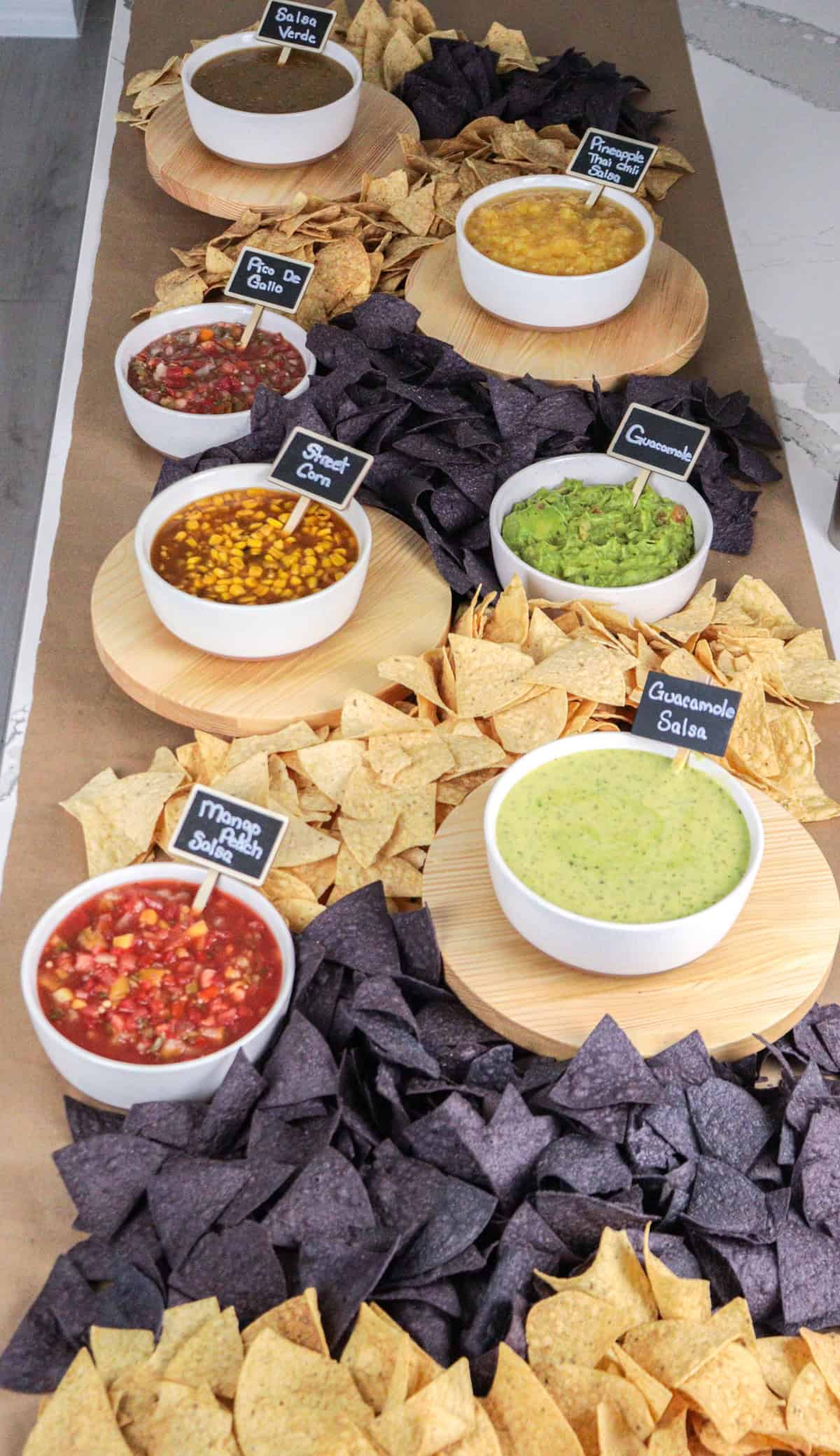Chips and salsa laid out on table with signs.