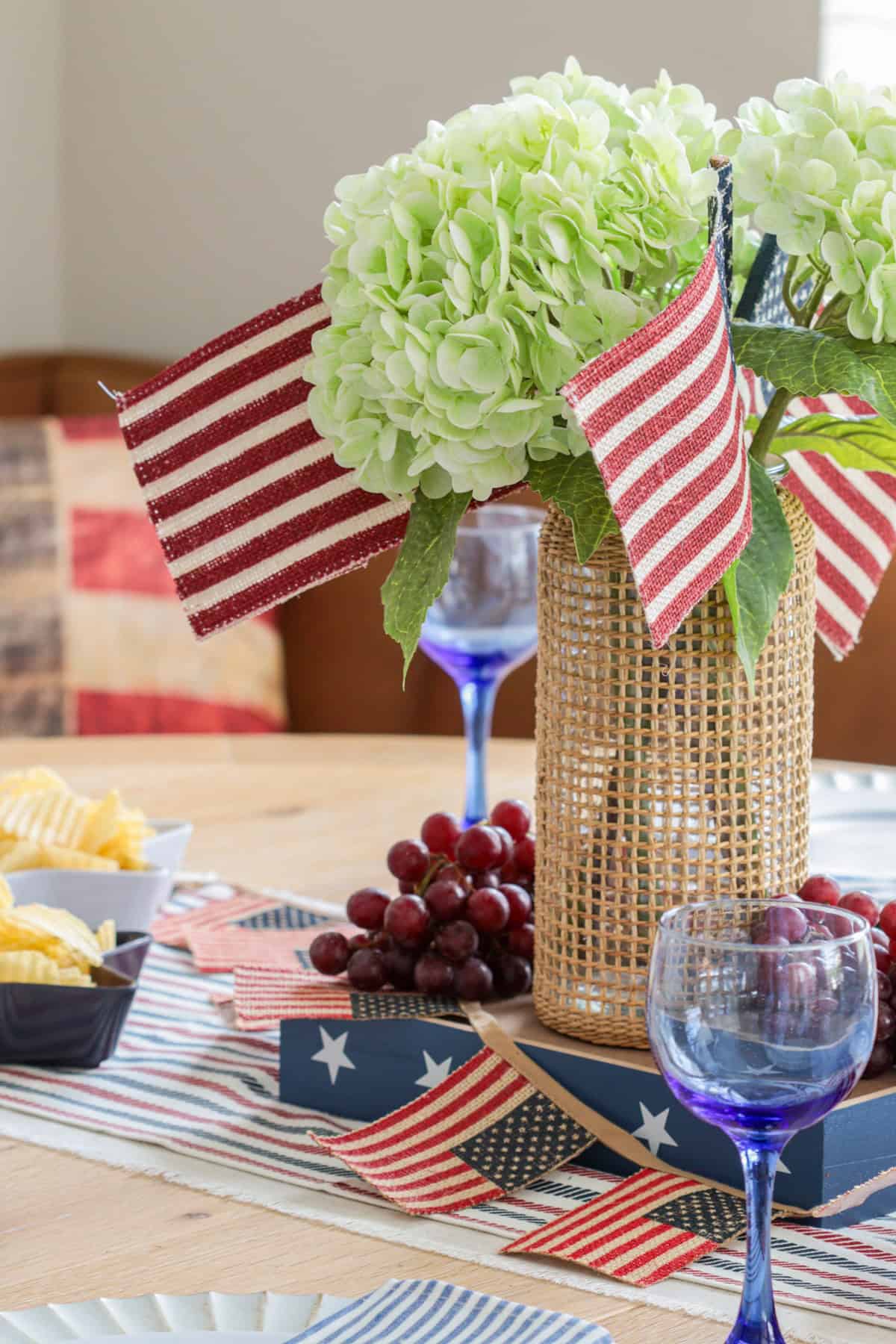Hydrangea centerpiece with American flags on table.