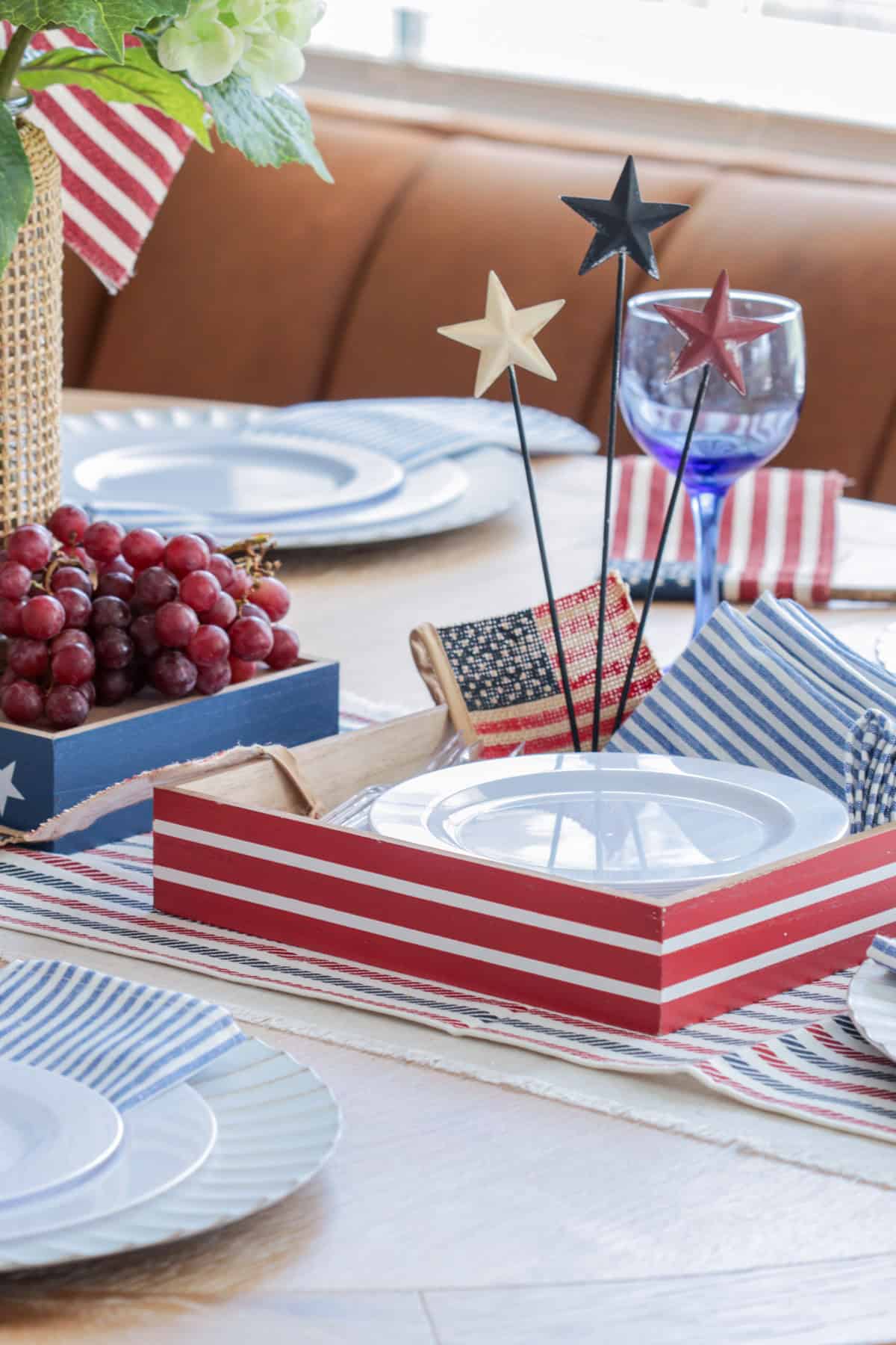 Red white and blue decor with red box holding plates and napkins.