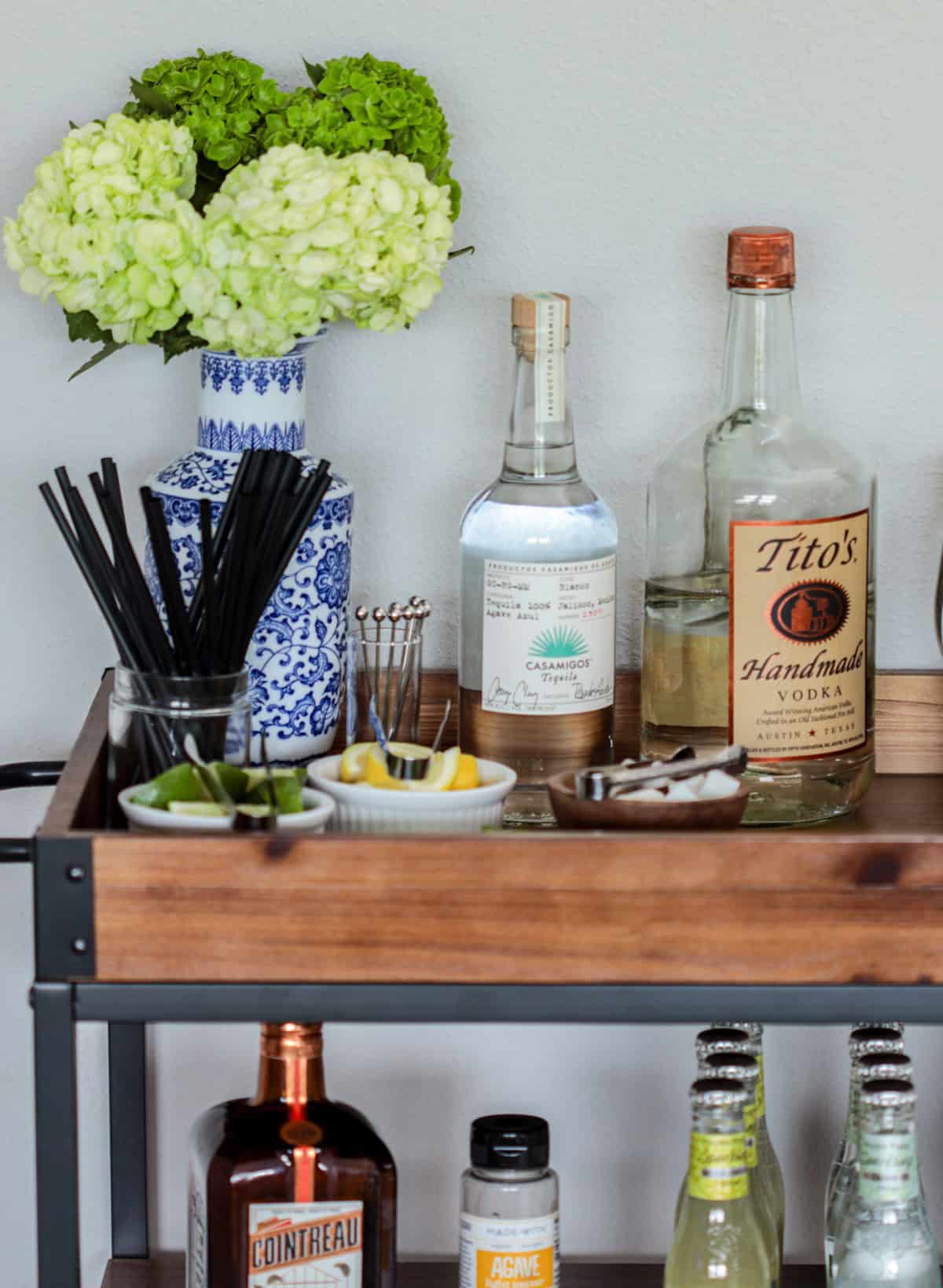 Summer inspired bar cart with fresh flowers and alcohol.