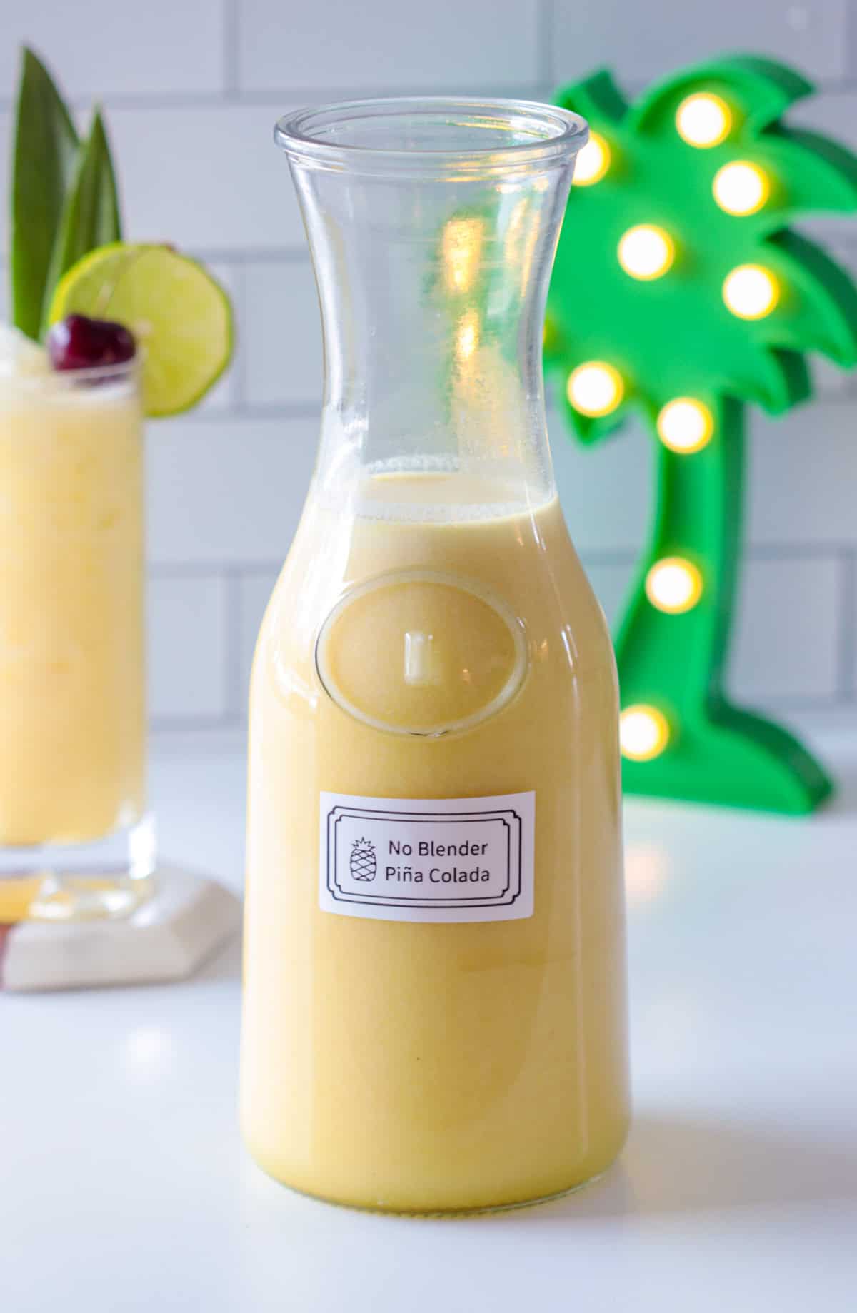 Pina colada in a pitcher with a label.