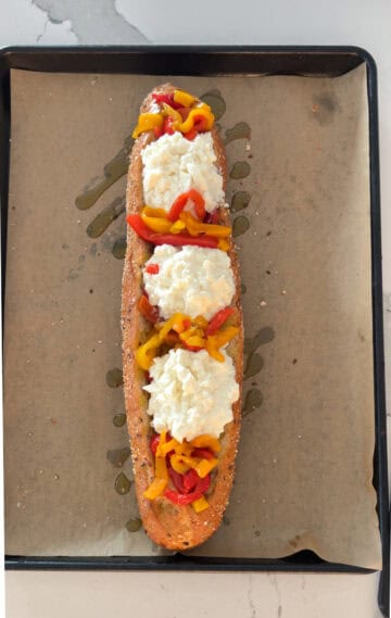 Bread with bell peppers and burrata cheese on top.