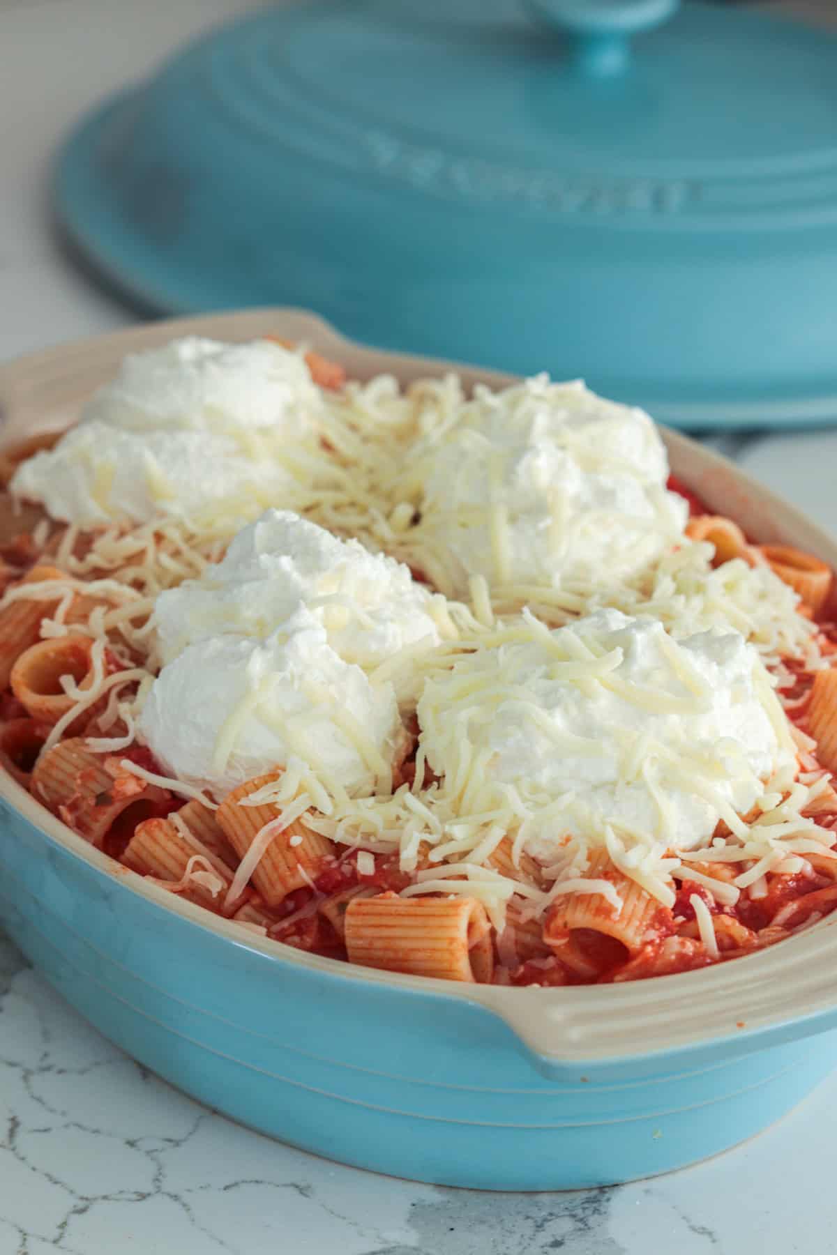 Baked ziti topped with ricotta and mozzarella cheese.