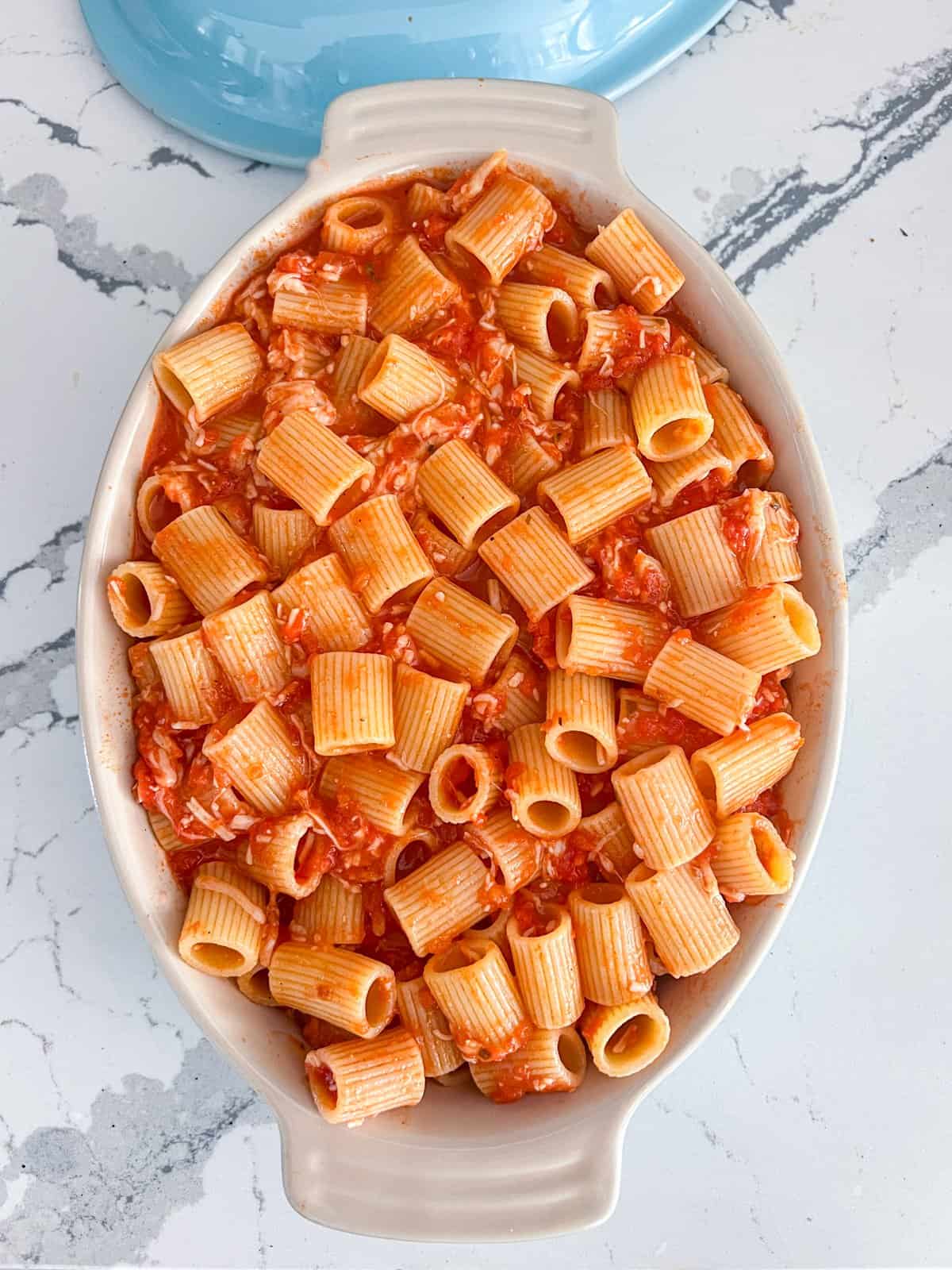 Baked ziti in a casserole dish before adding the ricotta cheese.