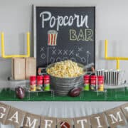 Popcorn bar with sign and popcorn on table.