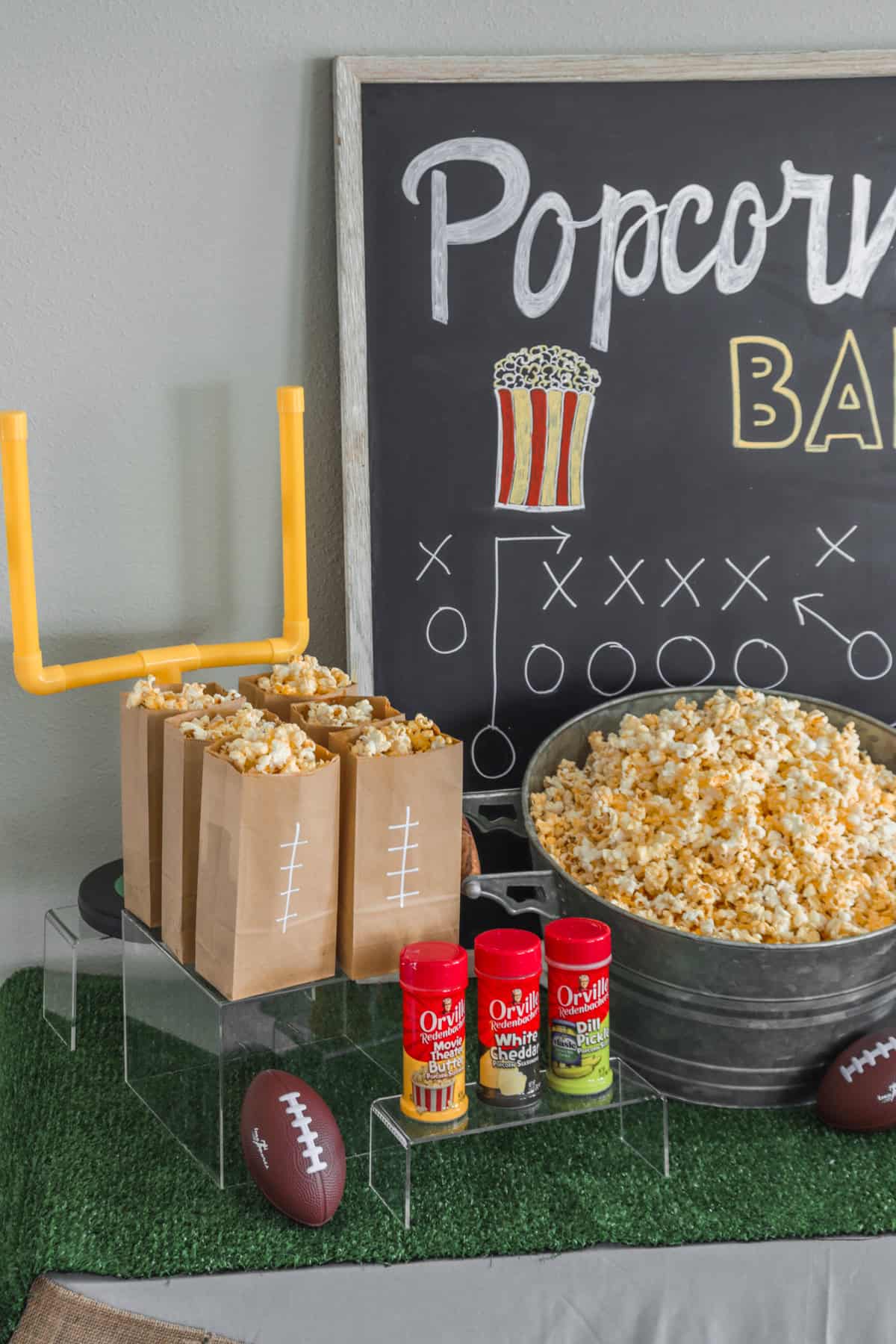 Popcorn bar with brown paper bags and a chalkboard sign.