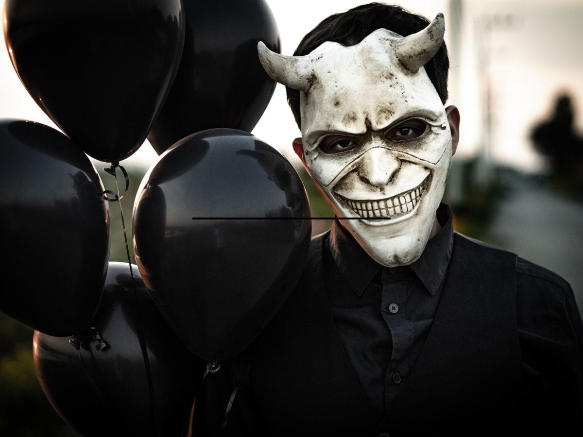 Person dressed in sinister Halloween costume with scary mask.